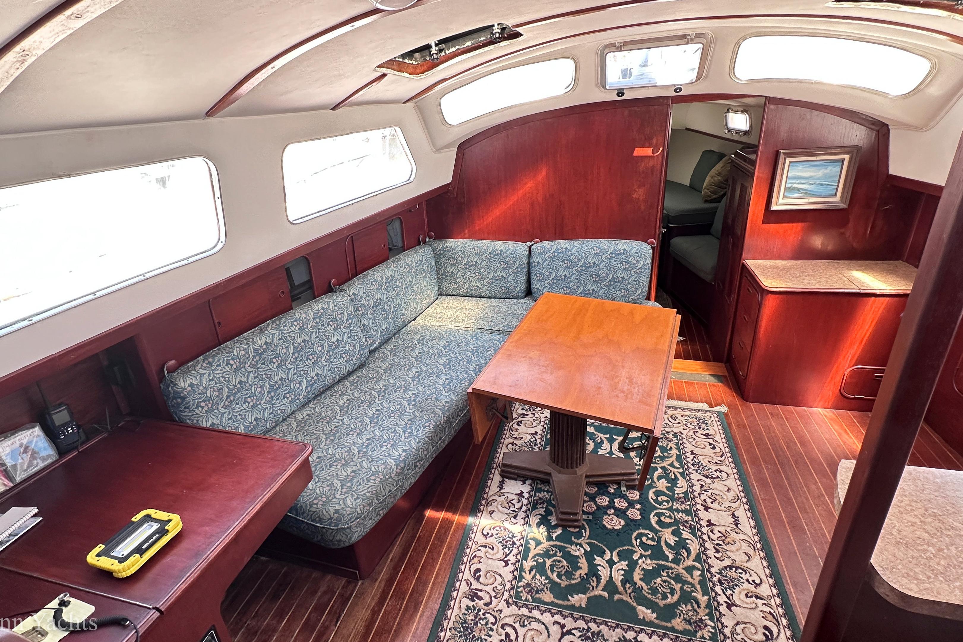 1980 Irwin 46 yacht interior with wooden furnishings and patterned upholstery.