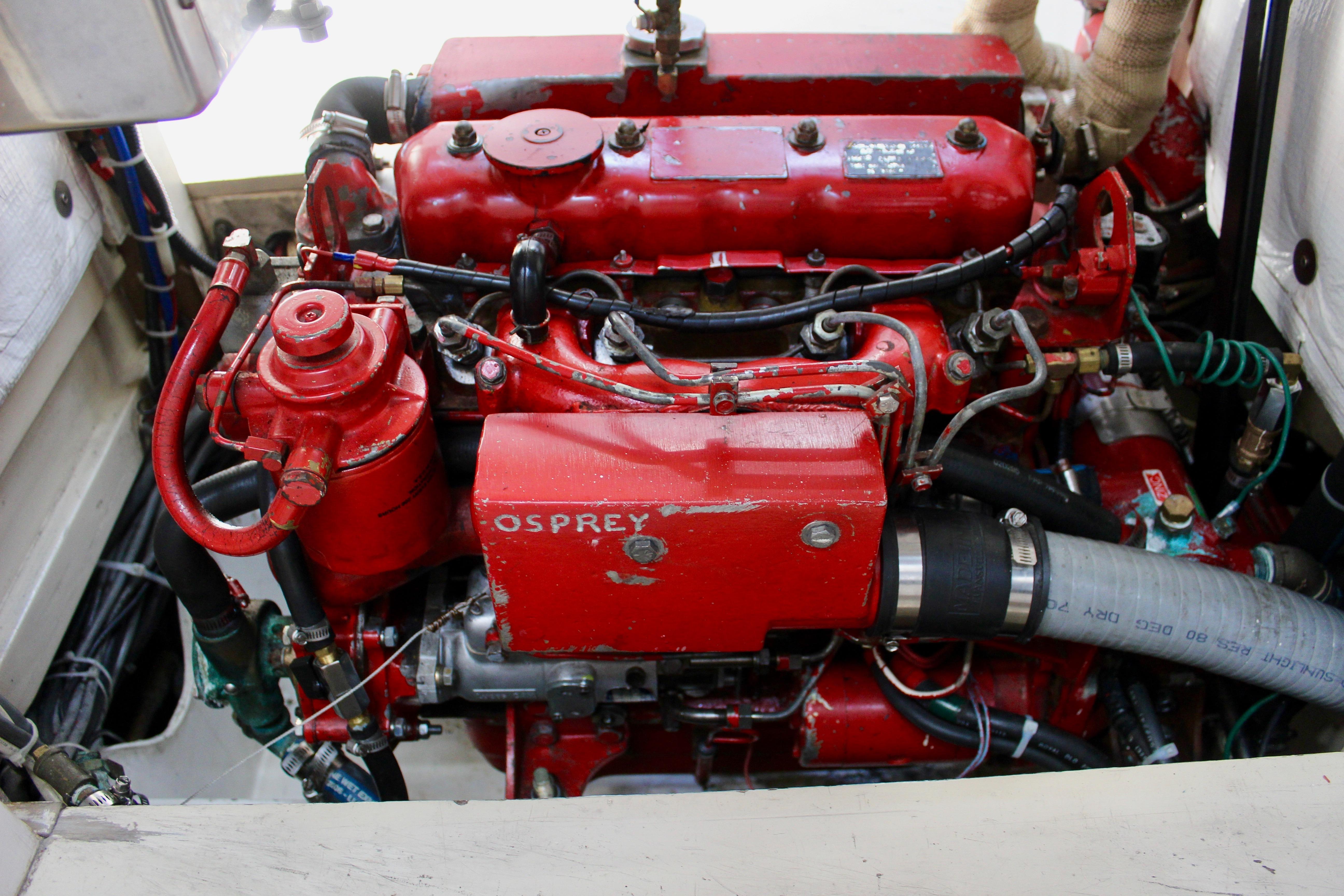 Red engine of a 1993 Freya 39 boat, labeled "Osprey," with visible hoses and components.