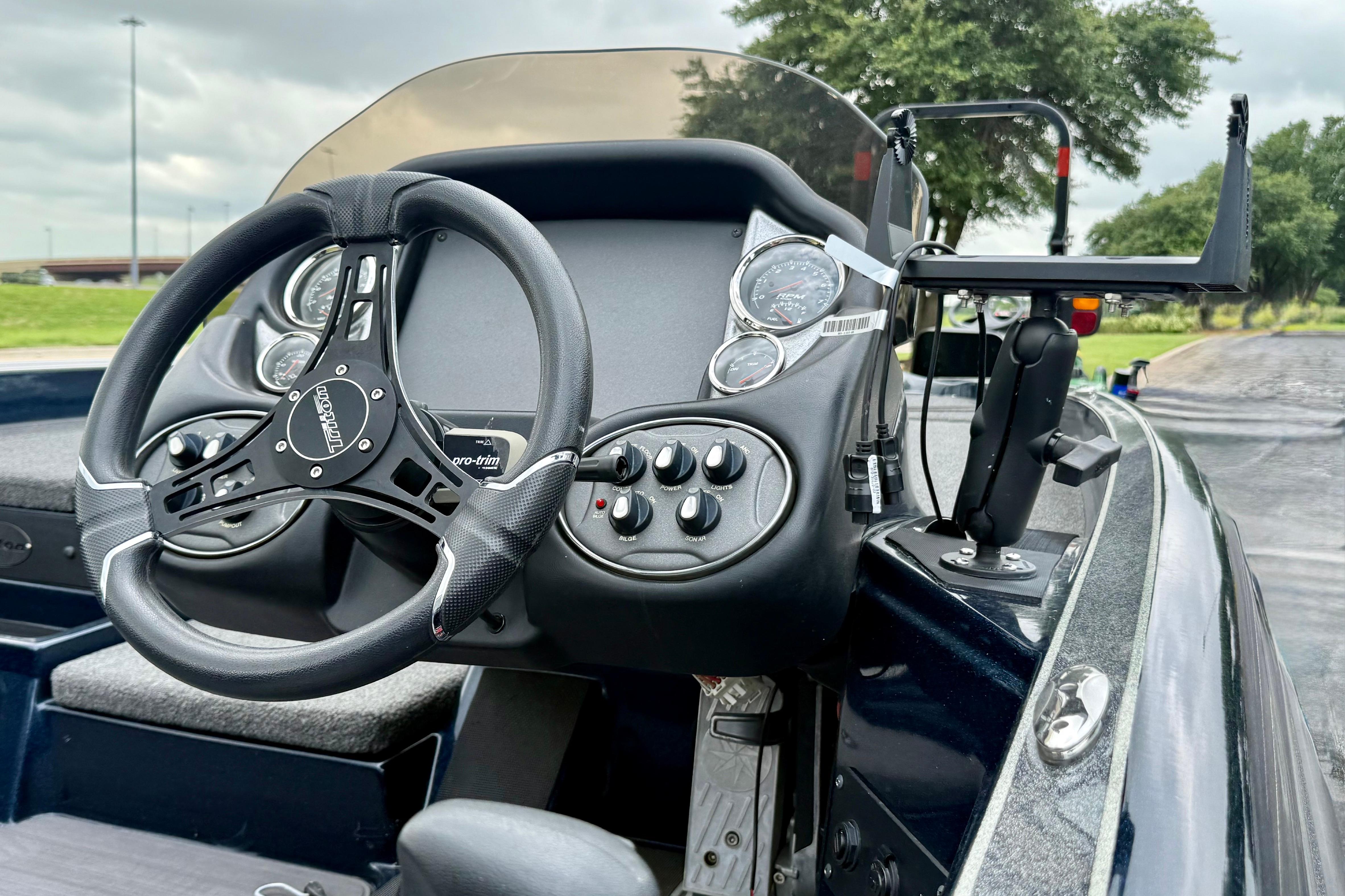 2023 Triton 18 TrX boat dashboard with steering wheel and control panel.