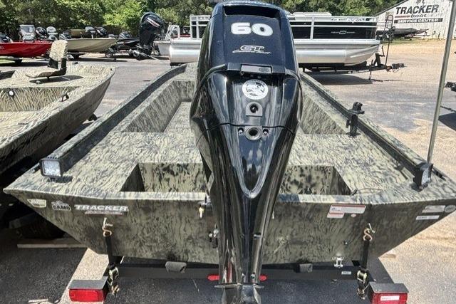 2026 Tracker Grizzly 1860 Utility boat with 60 HP engine, camo design, parked outdoors.