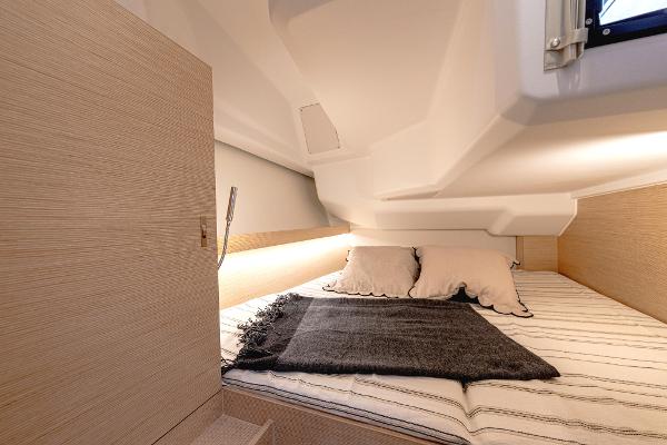 Cozy cabin interior of 2025 Hanse 360 yacht with bed and soft lighting.