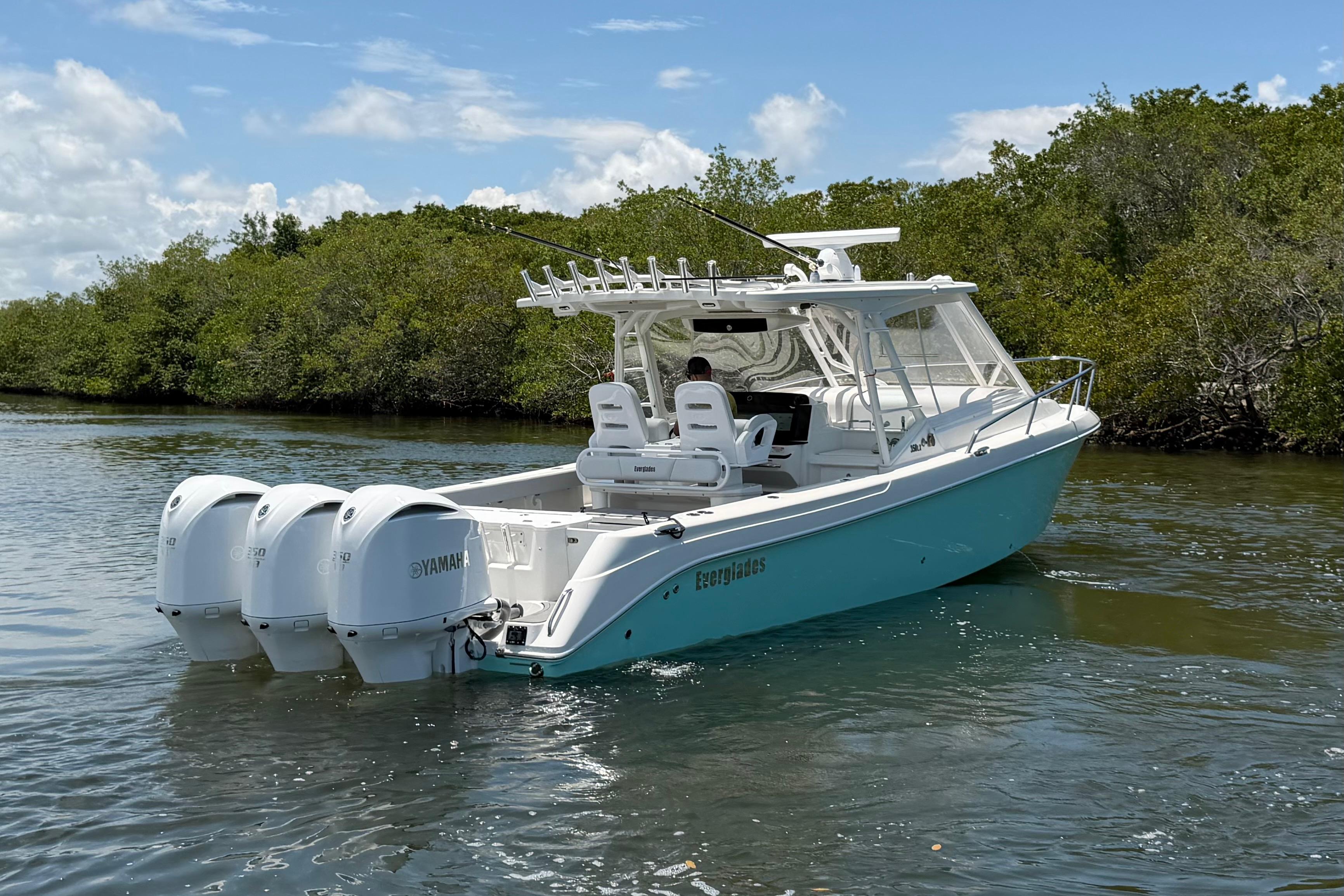 2009 Everglades 350LX boat with triple Yamaha engines on a calm waterway.