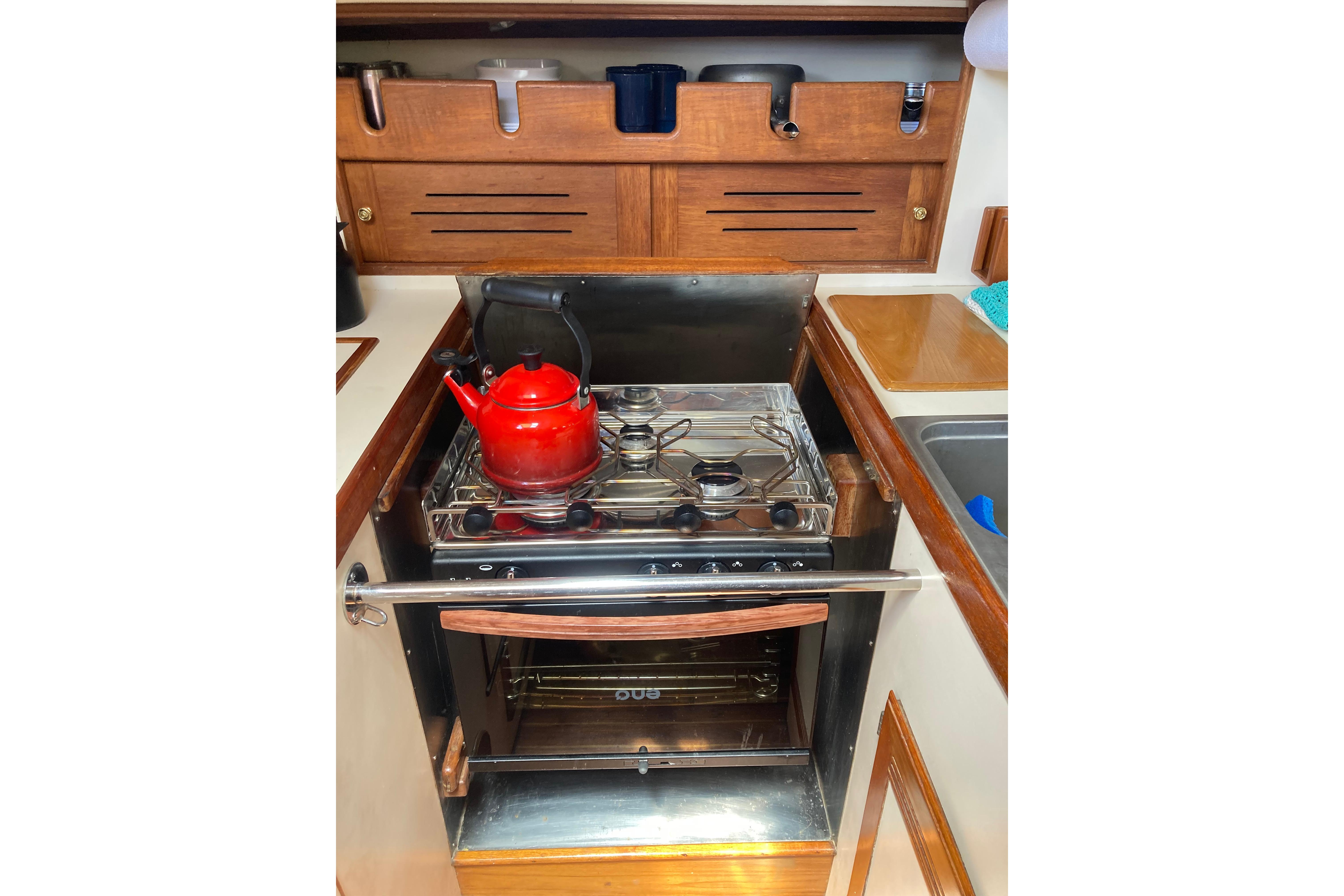 Galley kitchen in 1988 Cape Dory 36 sailboat with stove and red kettle.