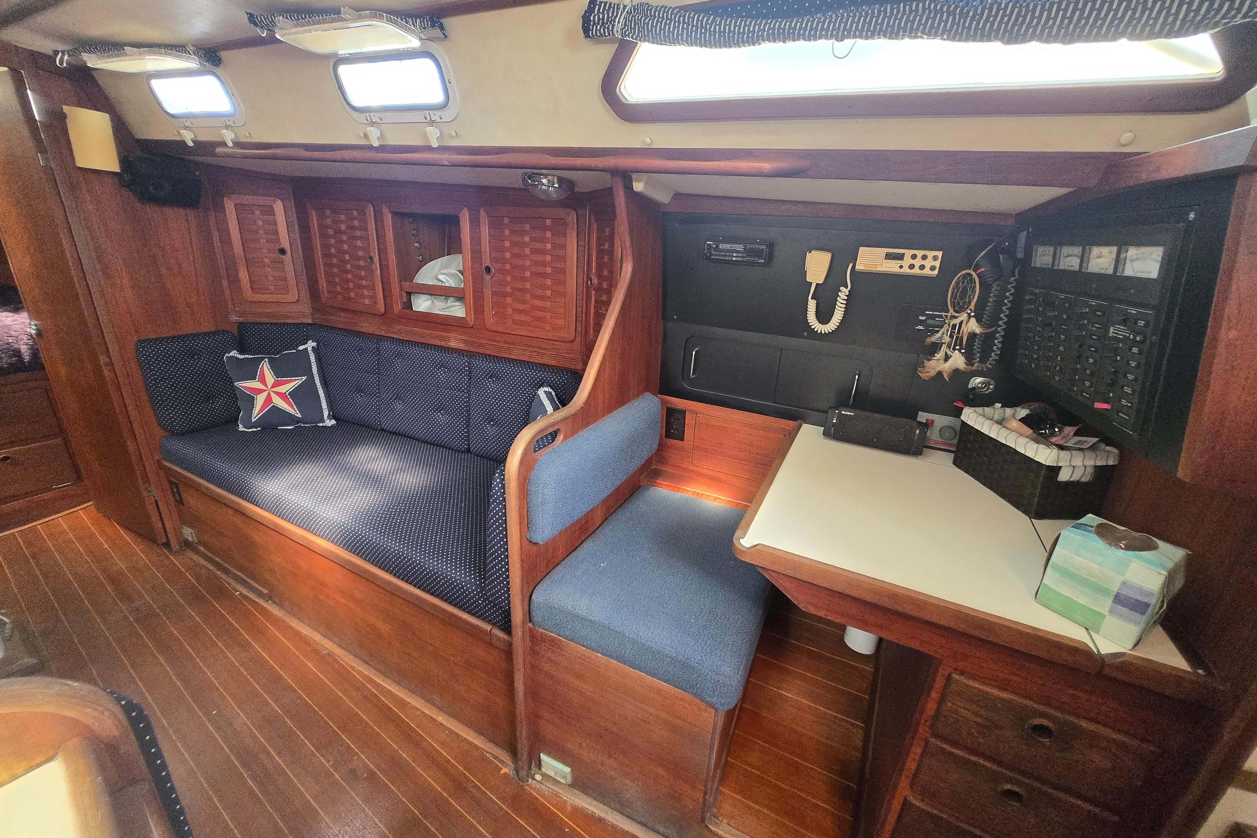 Interior of 1988 Sabre 38 sailboat with wooden cabinetry and blue seating.