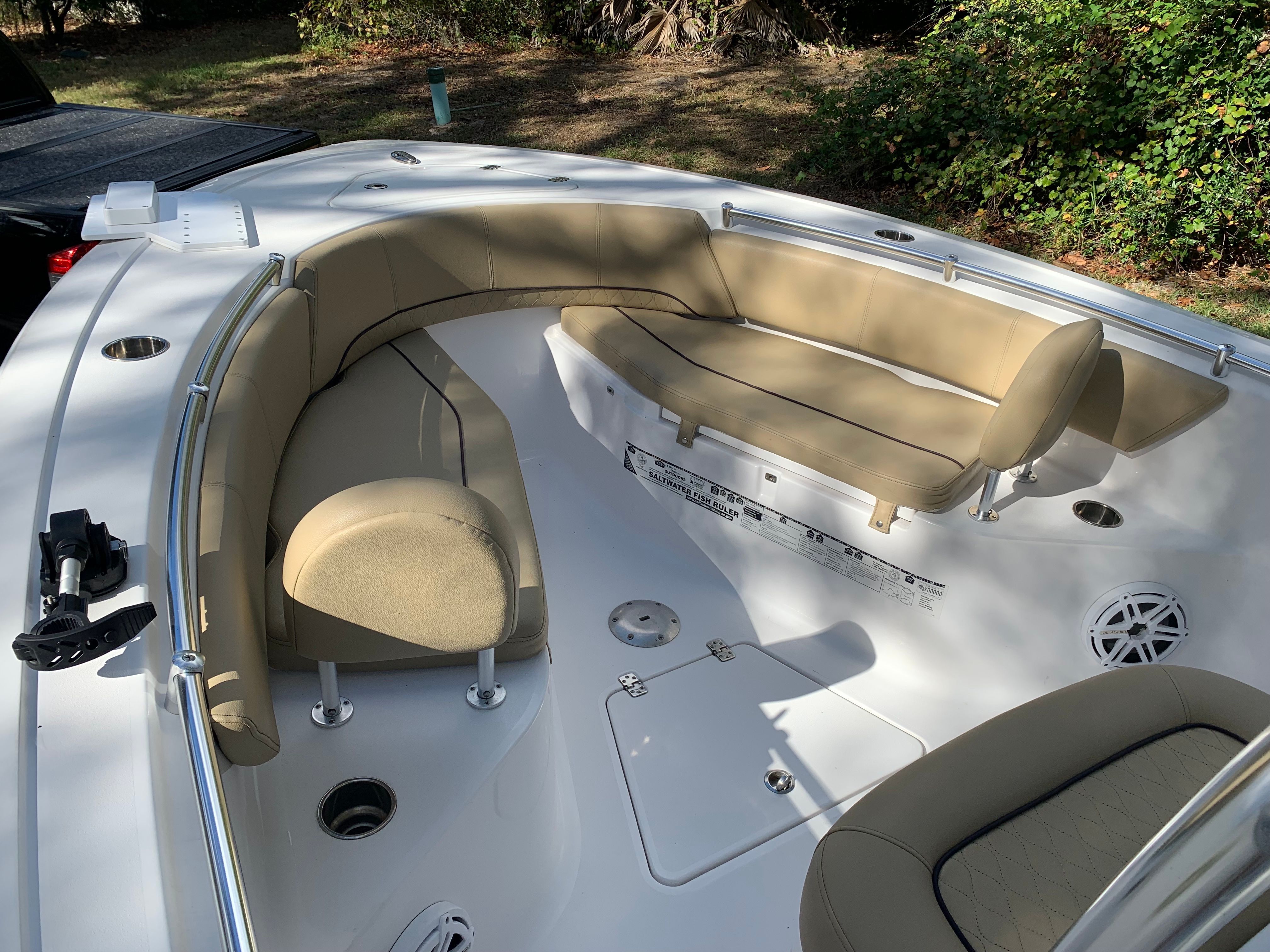 The image shows the bow of a Sportsman Heritage 241 Center Console boat with beige cushions.