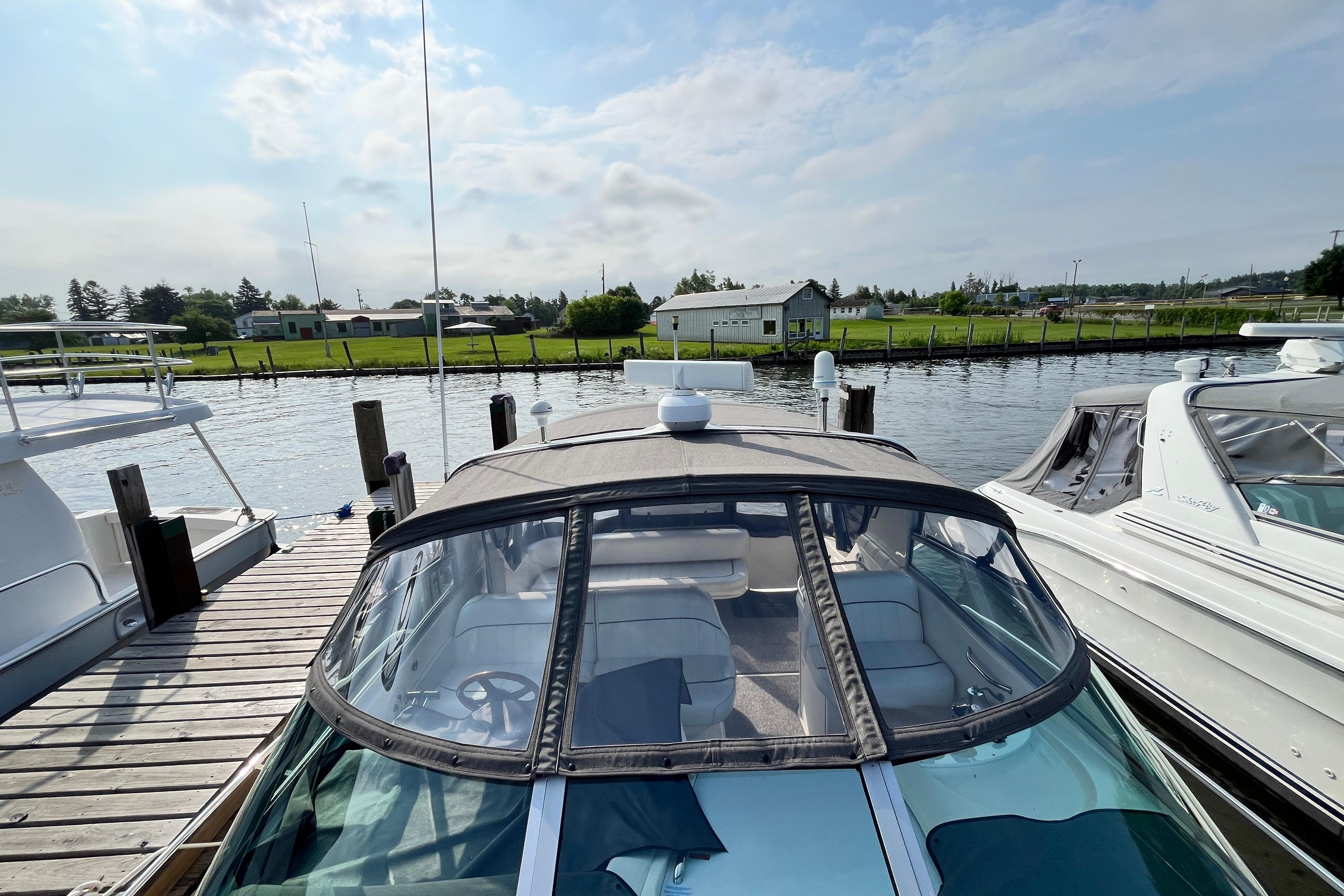 1995 Sea Ray Sundancer 330 docked at a marina, showcasing its sleek design and covered cockpit.