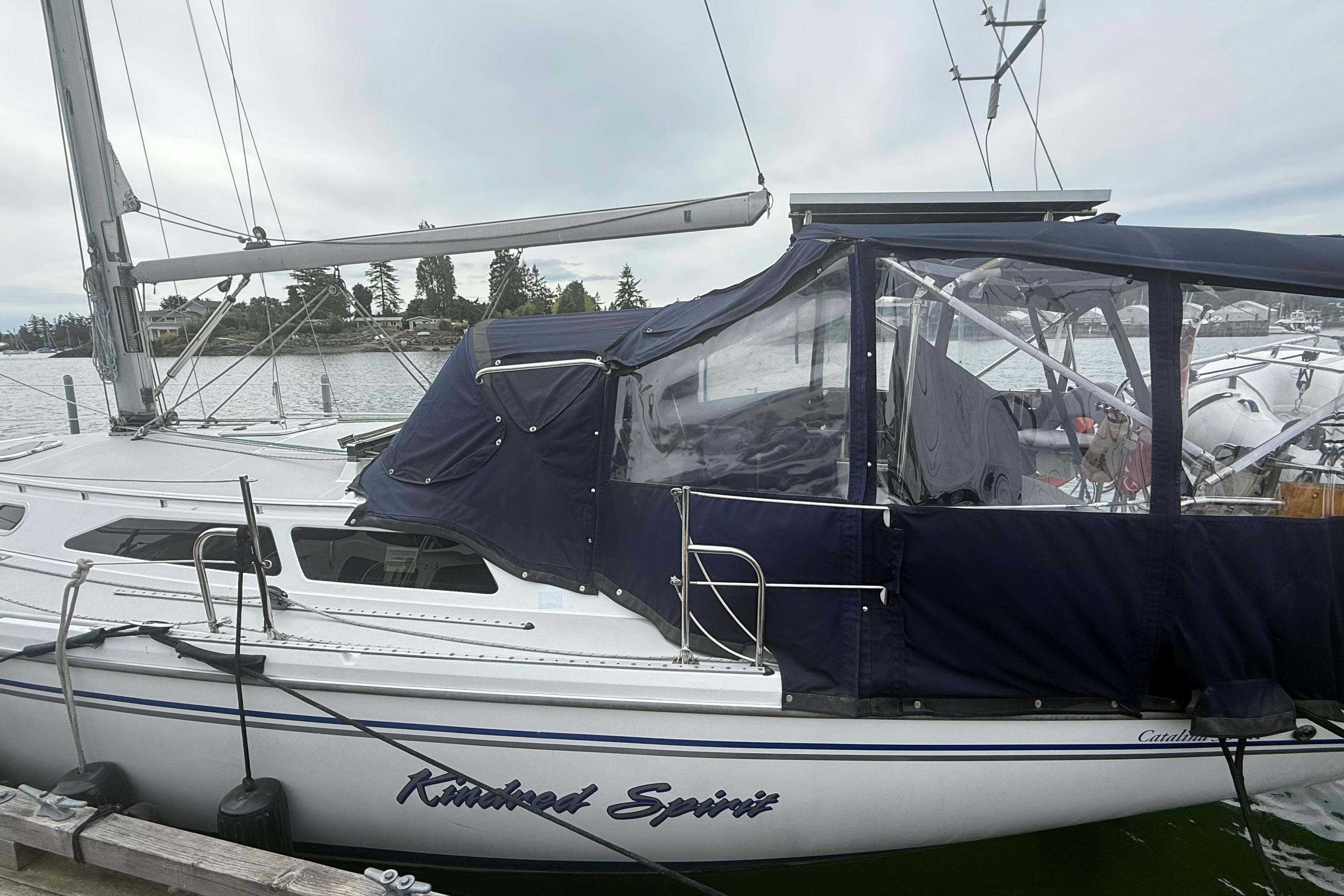 2005 Catalina 36 MkII sailboat docked with blue canopy and clear windows.