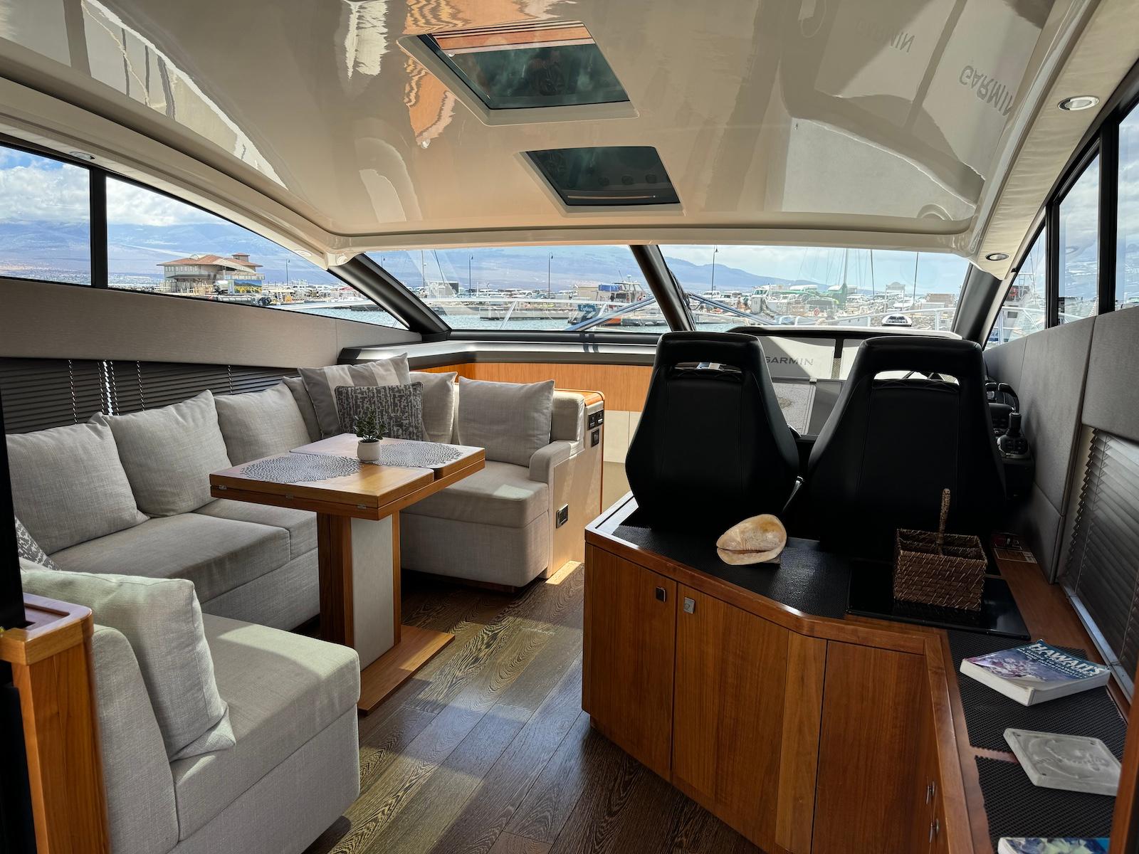Luxurious interior of 2017 Sunseeker Predator 57 yacht with plush seating and panoramic windows.