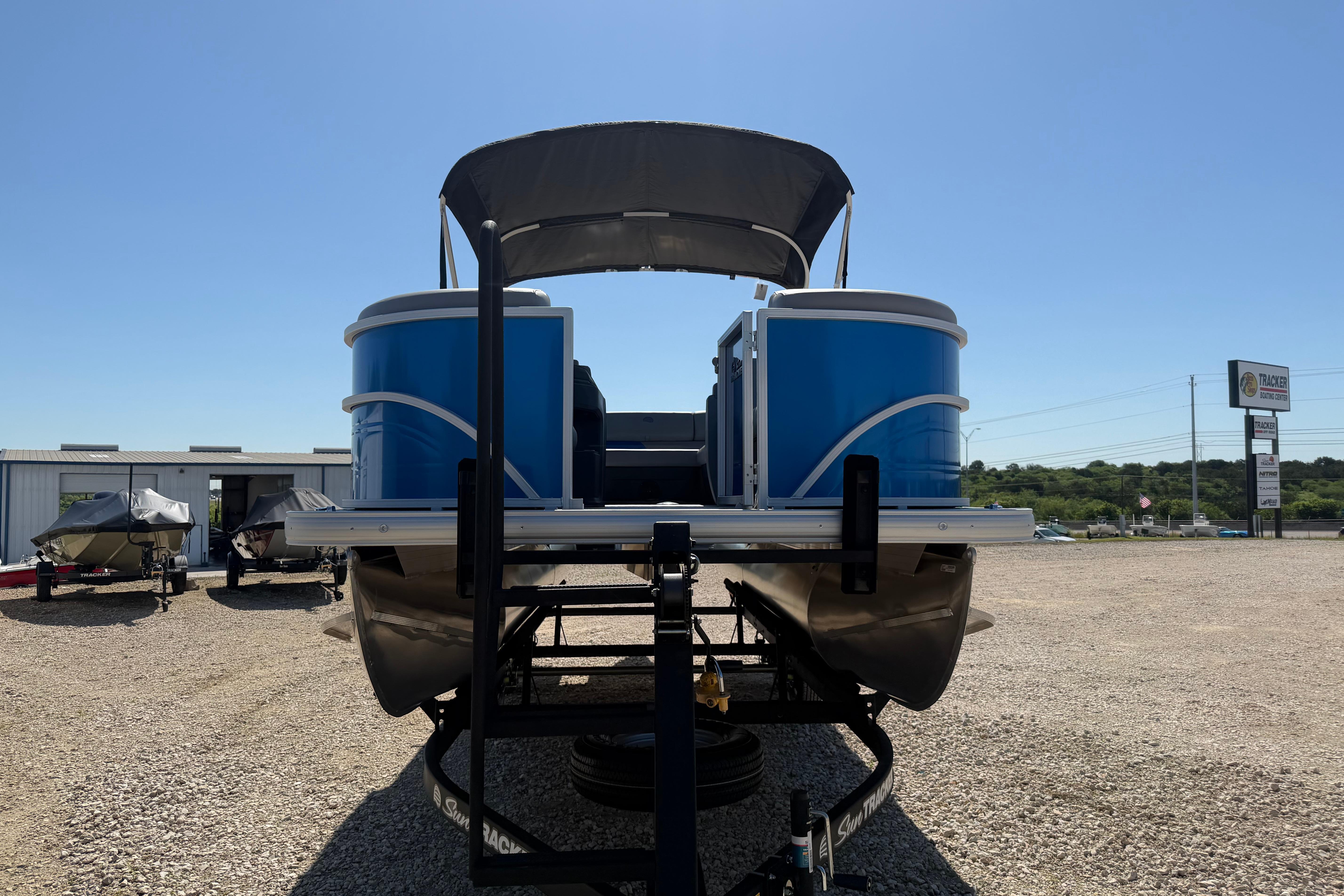 2026 Sun Tracker Party Barge 20 DLX pontoon boat on trailer, sunny day.