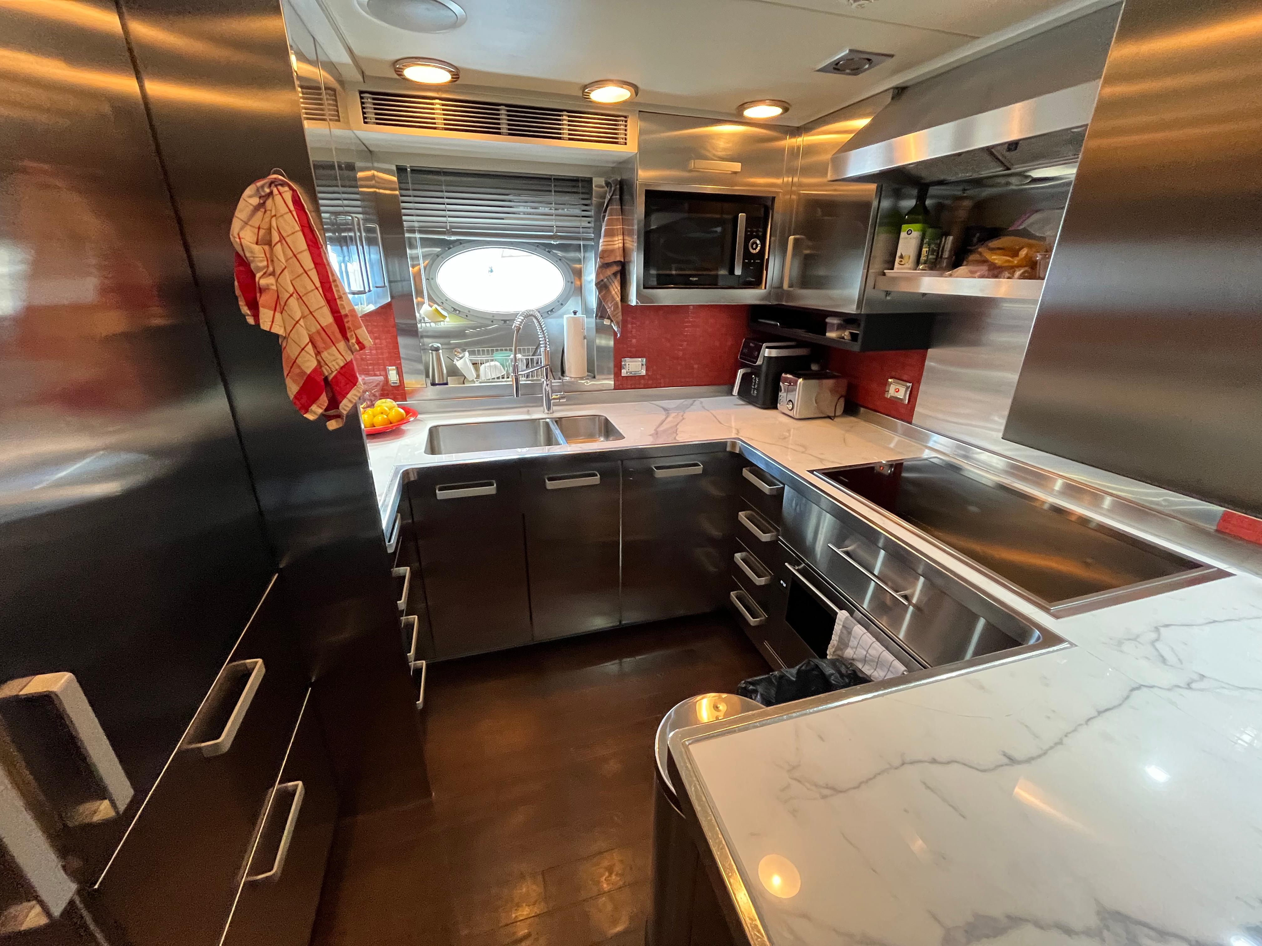 Modern kitchen interior on a 2008 Palmer Johnson 120 yacht, featuring stainless steel appliances.