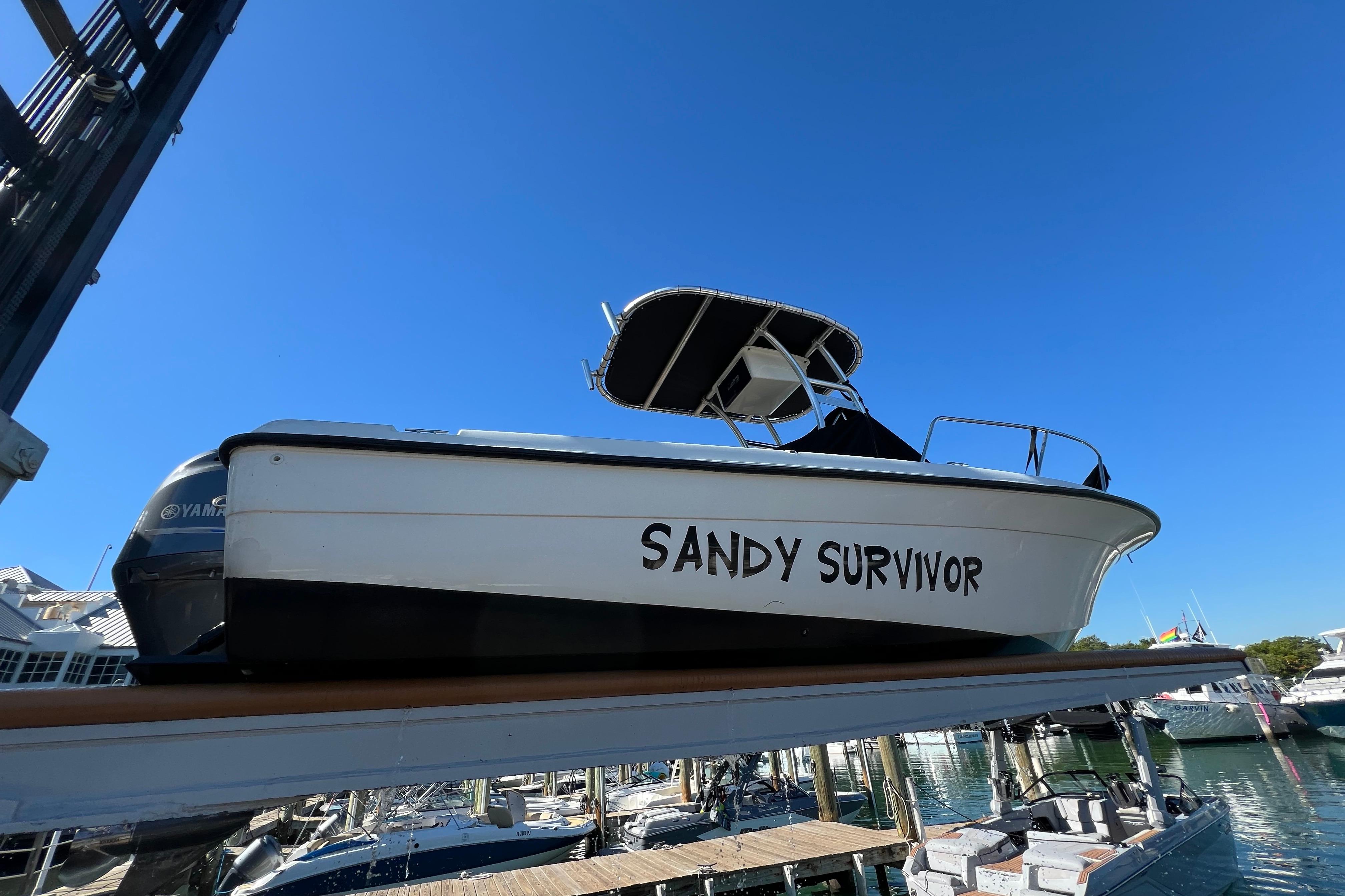 2004 Hydra-Sports 212 CC boat named "Sandy Survivor" docked under clear blue sky.