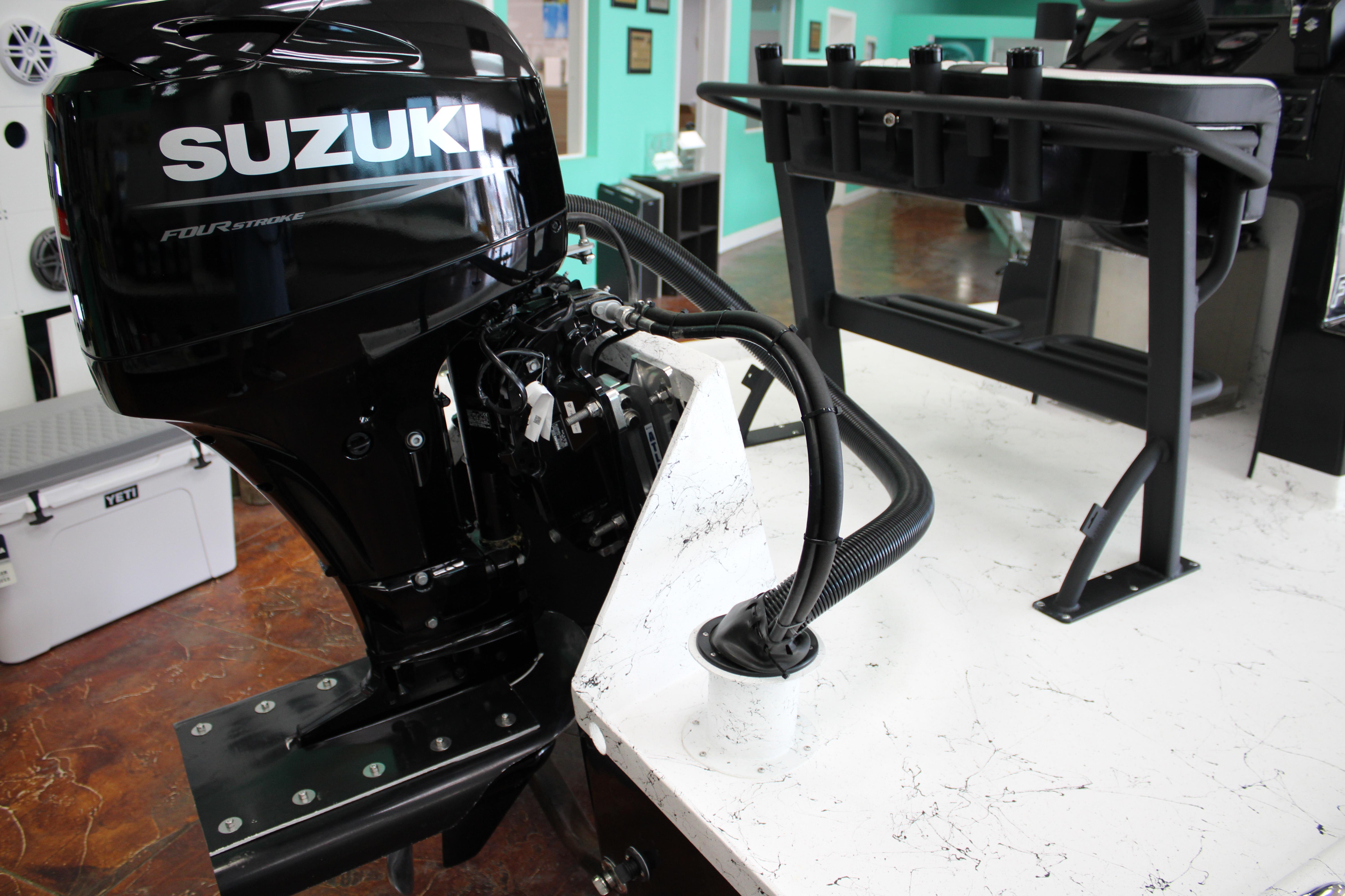 2026 Freedom Boats Chiquita with Suzuki outboard motor in showroom setting.