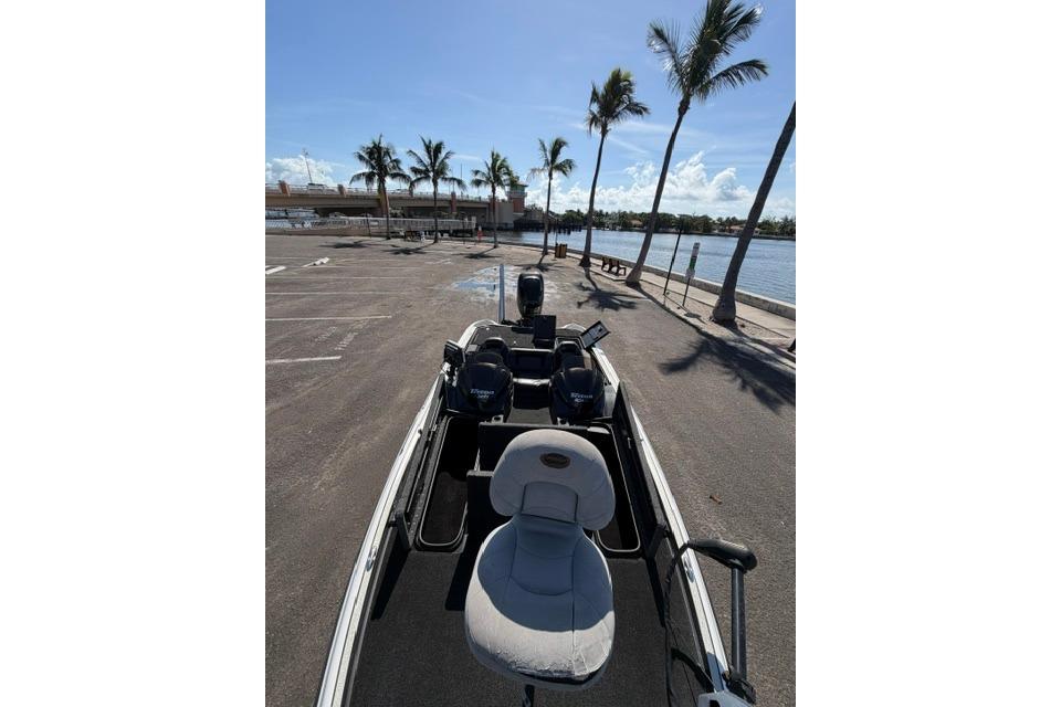 2005 Triton Tr-21X PD boat parked near waterfront with palm trees and clear sky.