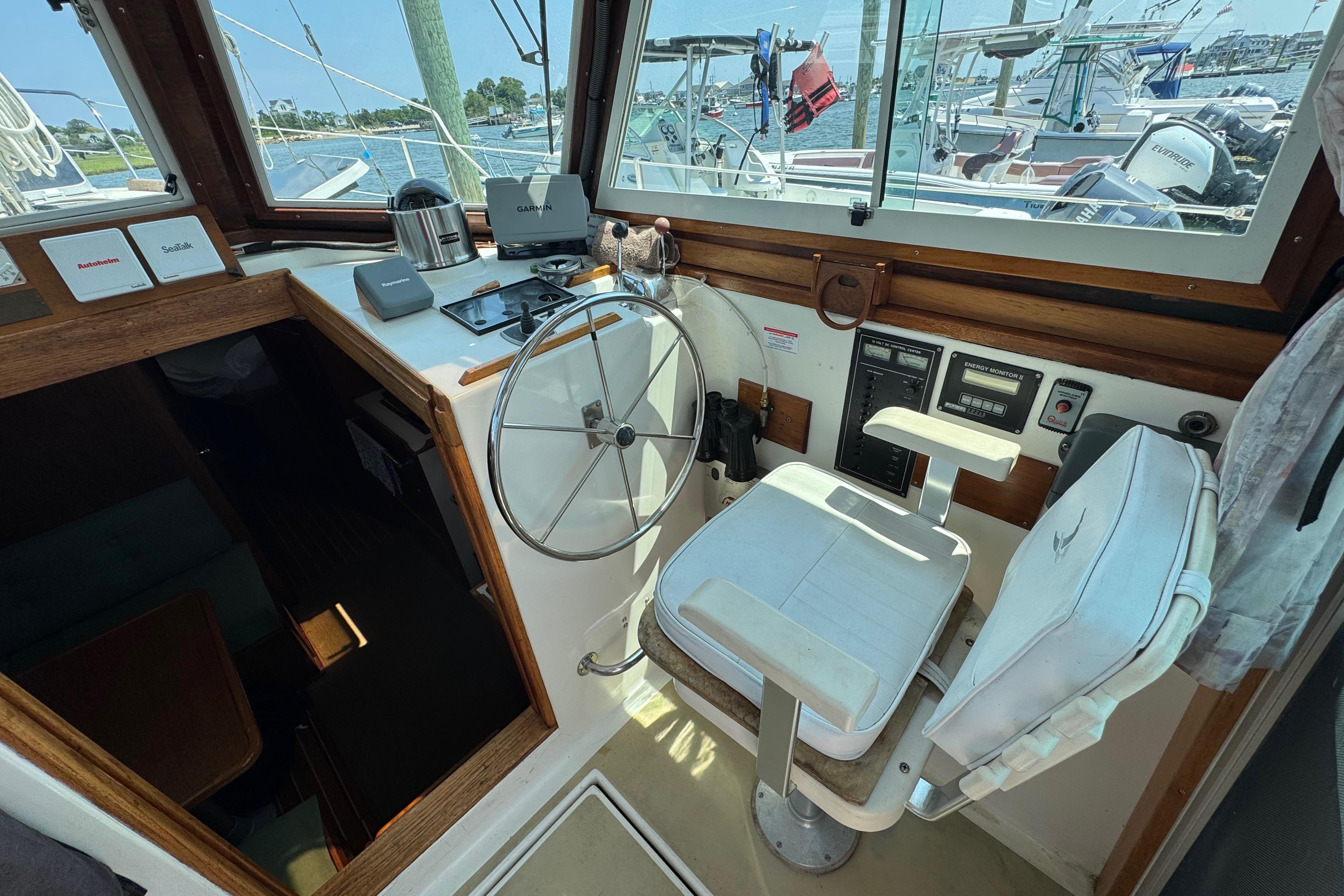 Interior helm of 1989 Cape Dory 30 Motorsailer with steering wheel and navigation equipment.