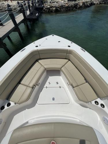 2019 Pursuit S 408 Sport boat with beige seating, docked by clear water.