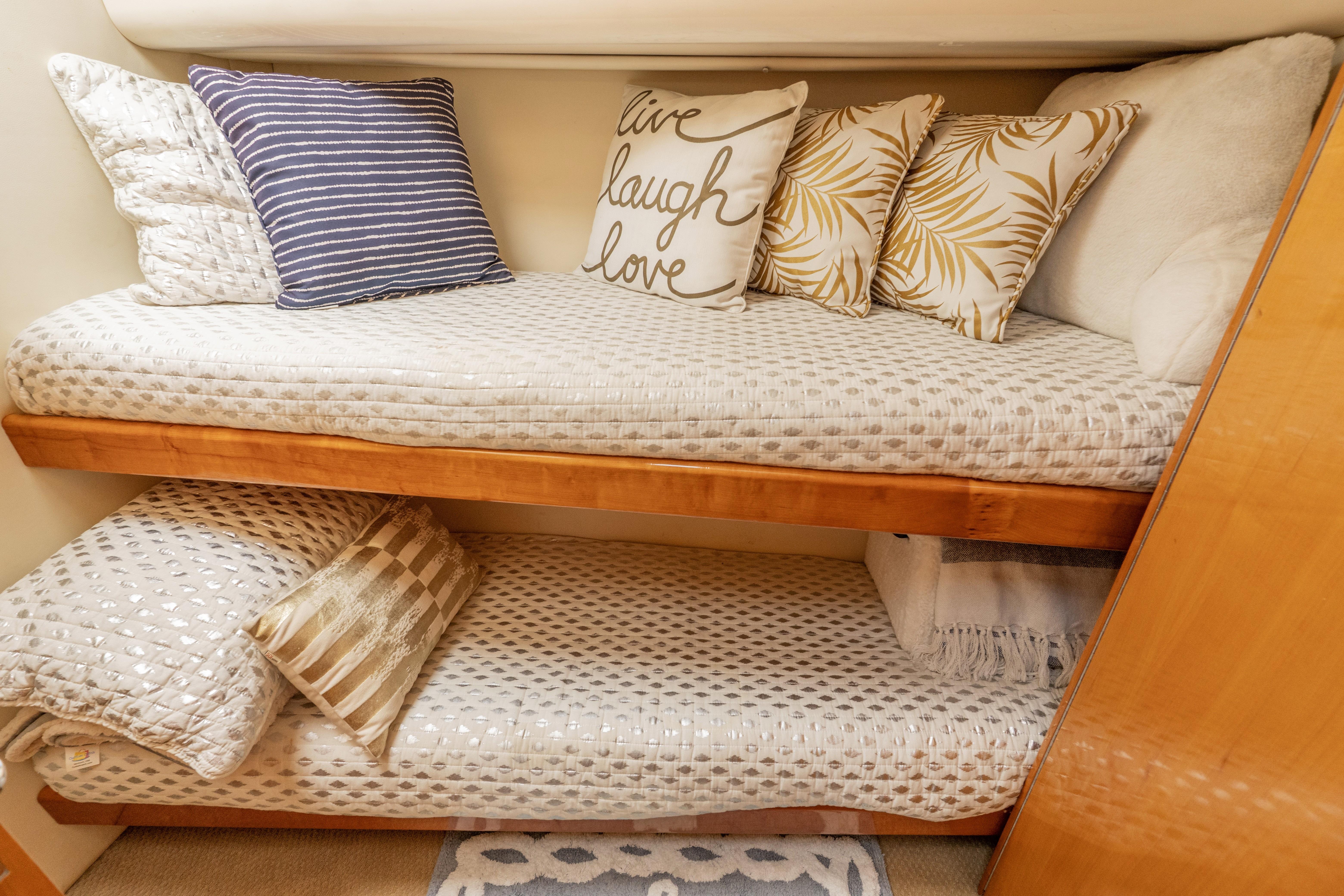 Cozy bunk beds with decorative pillows in a 2008 Maritimo 52 yacht cabin.