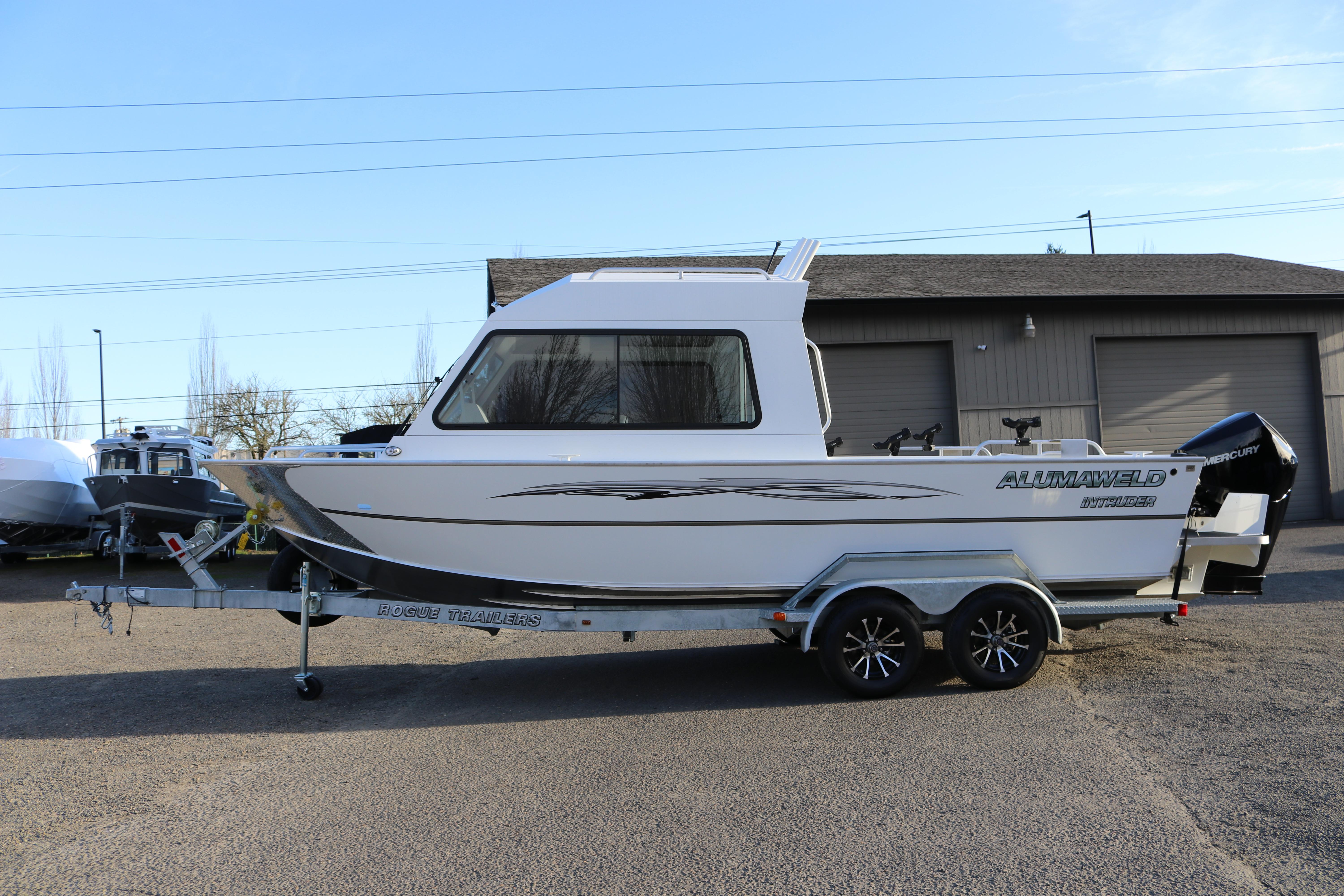 2026 Alumaweld Intruder Outboard 22 boat on trailer, parked outdoors.