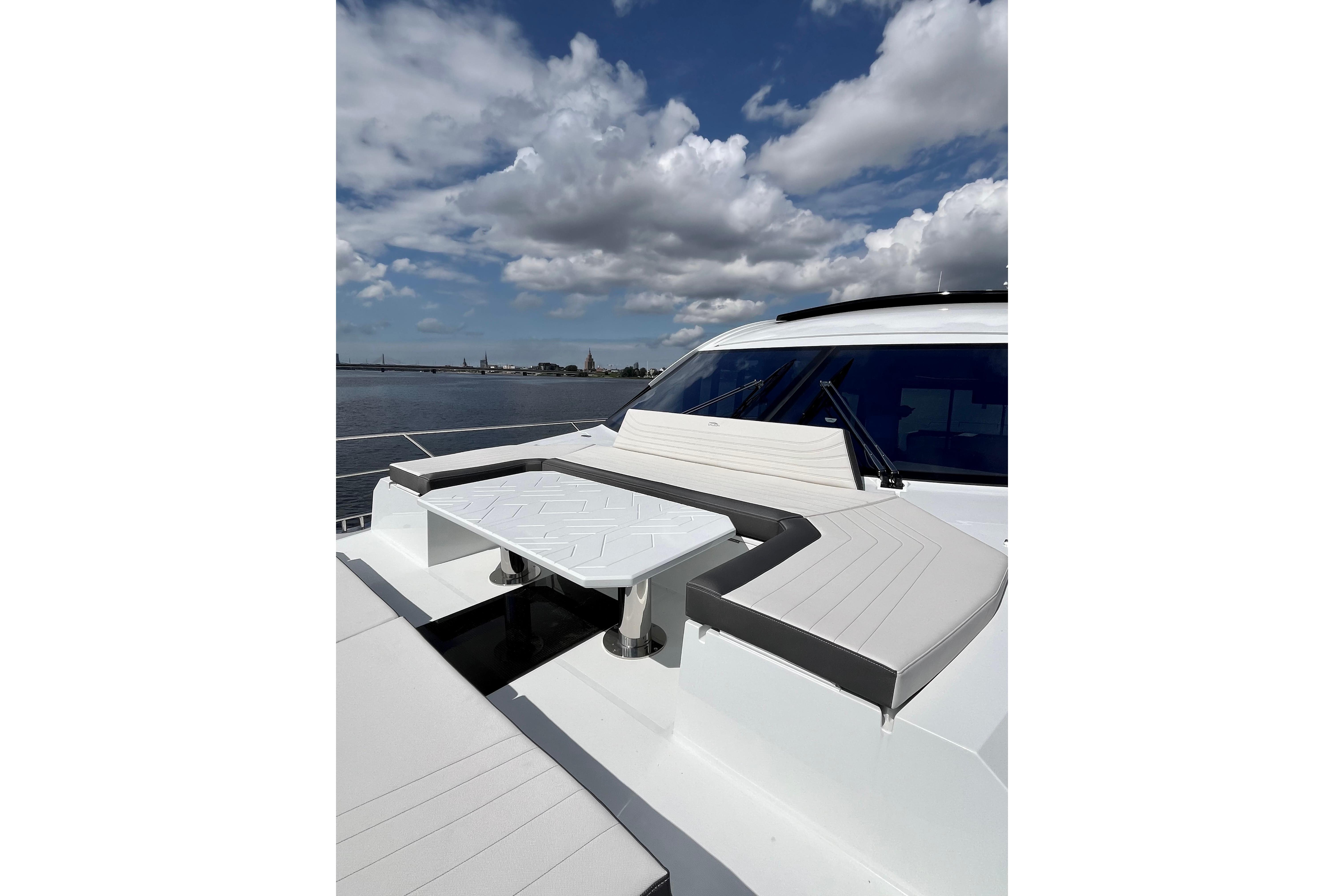 Luxurious 2025 Galeon 700 Sky yacht deck with seating and table under a cloudy sky.