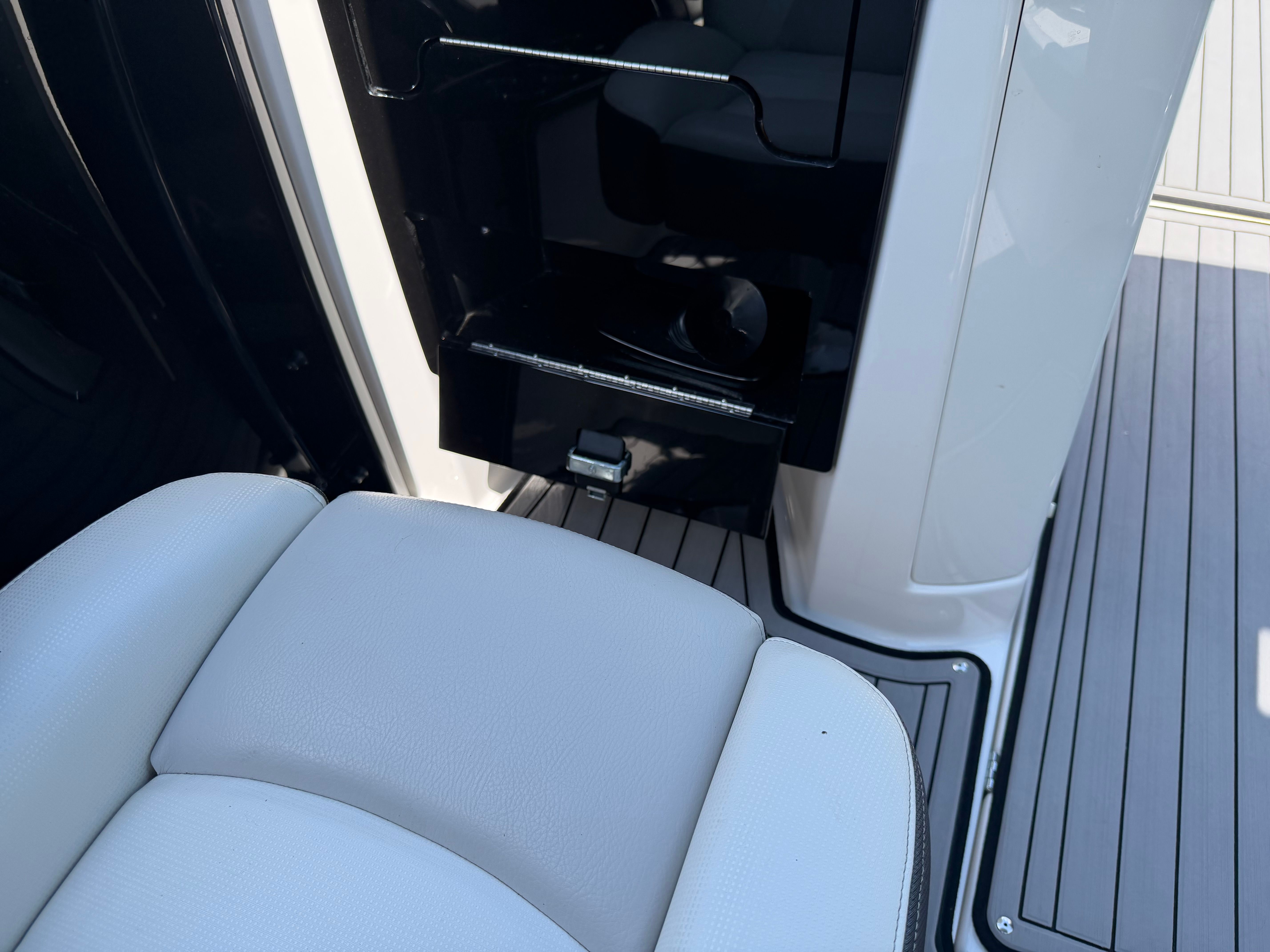 Close-up of a seat and storage compartment on a boat.