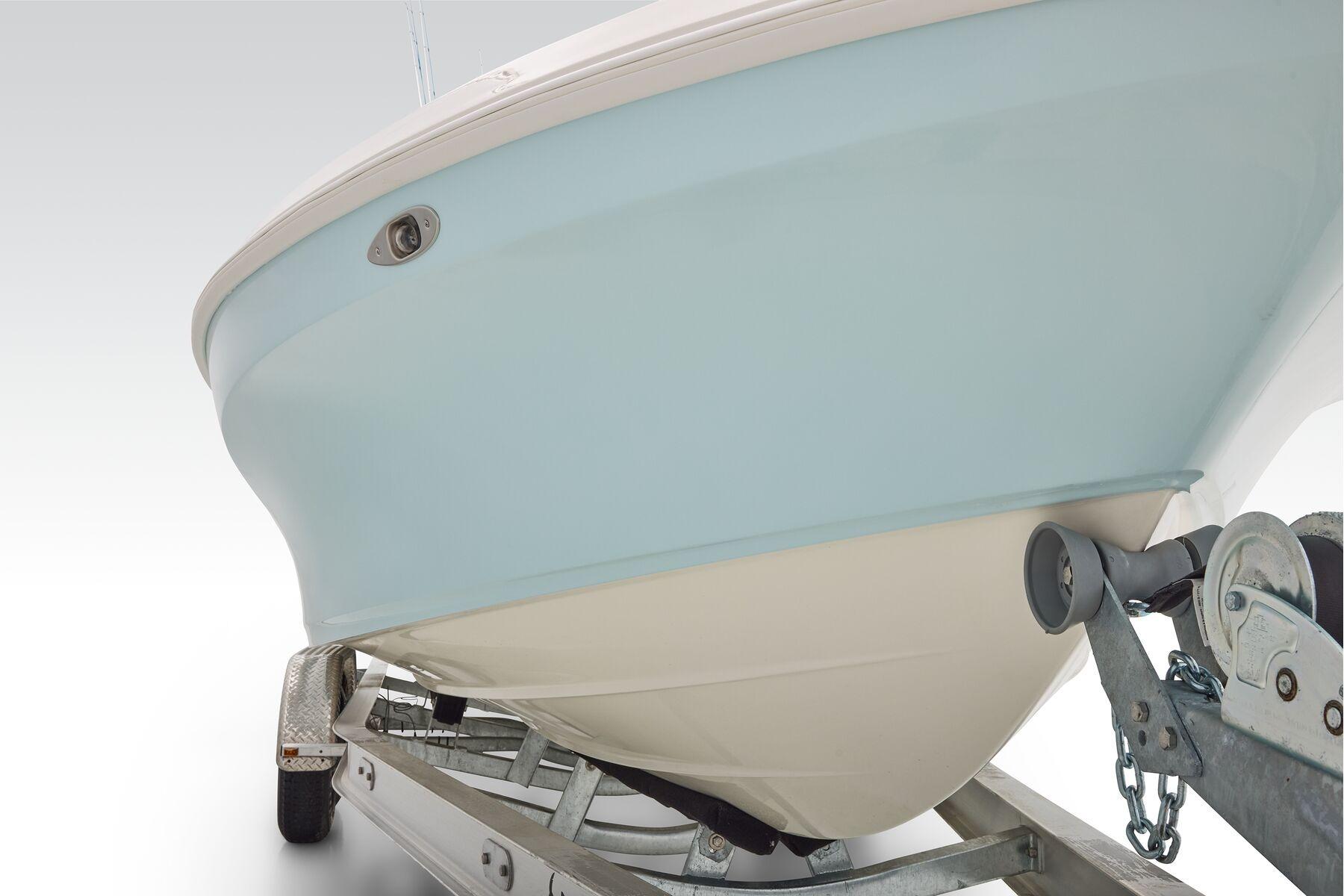 2026 Mako 24 APEX boat on trailer, showcasing sleek hull design.