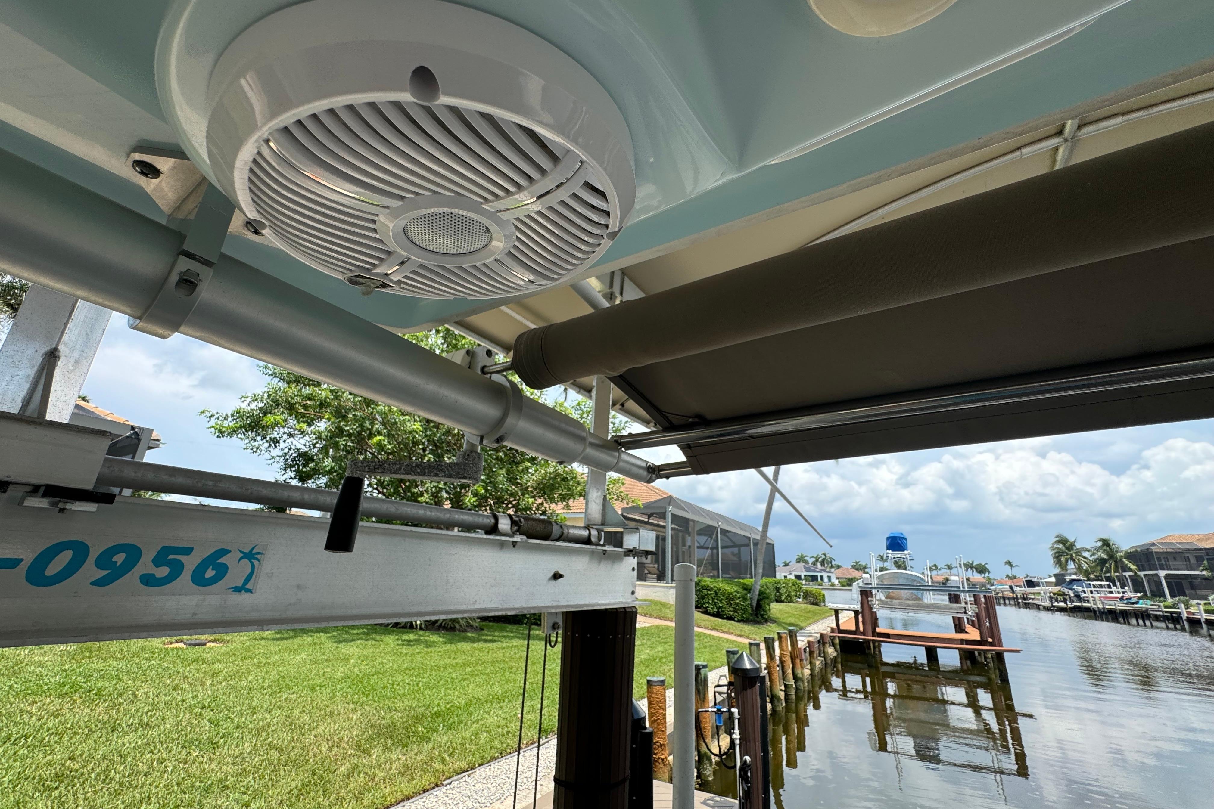 2021 Sailfish 276 DC boat speaker and dock view with lush greenery.