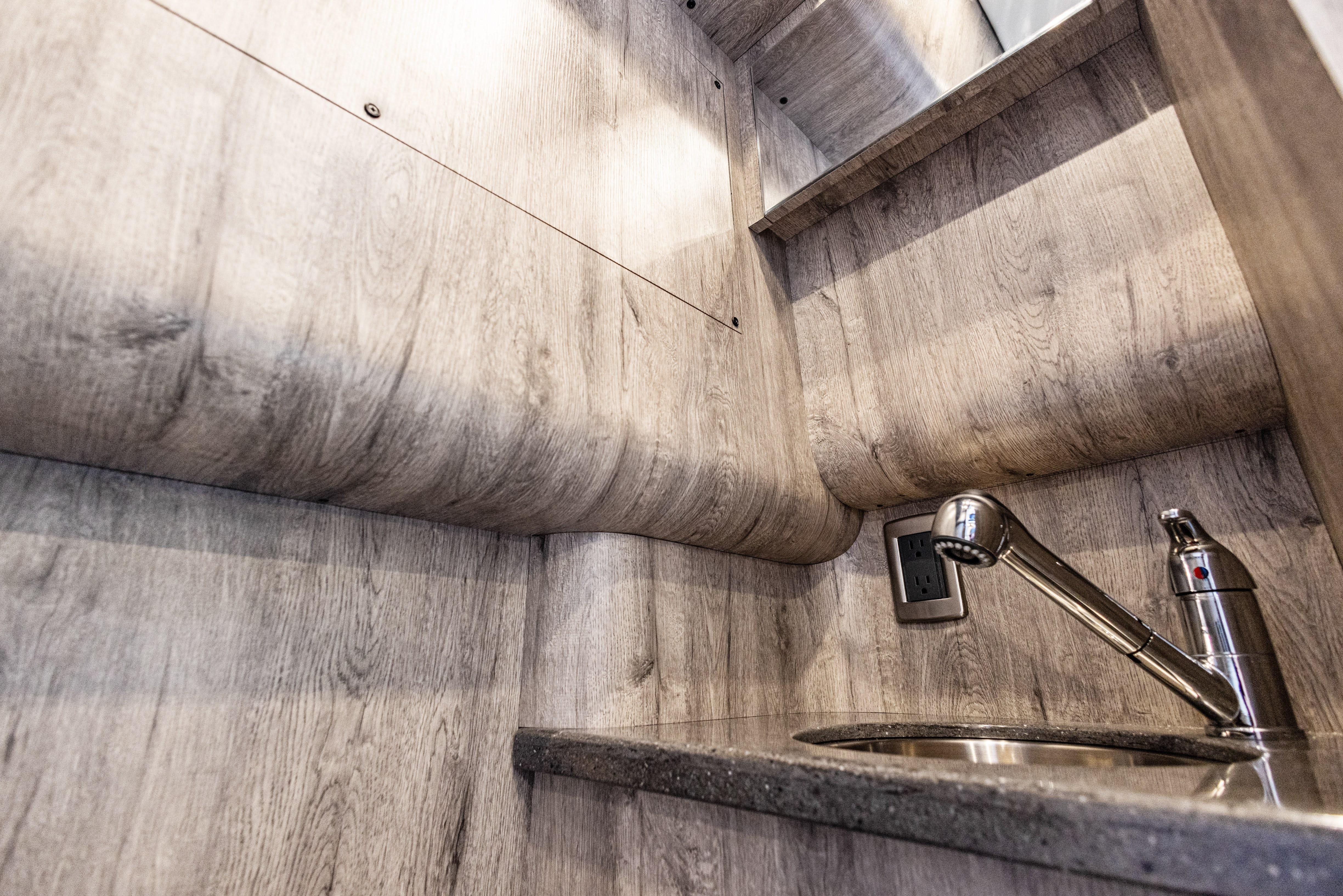 Interior of 2026 Mystic Powerboats M4200, featuring a sleek sink and modern wood finish.