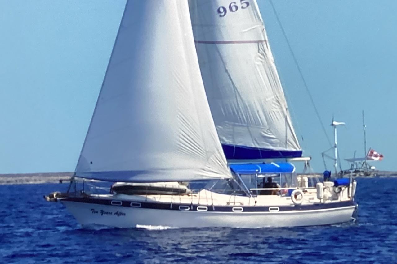 1987 Morgan Classic 41 sailboat navigating blue waters under full sail.