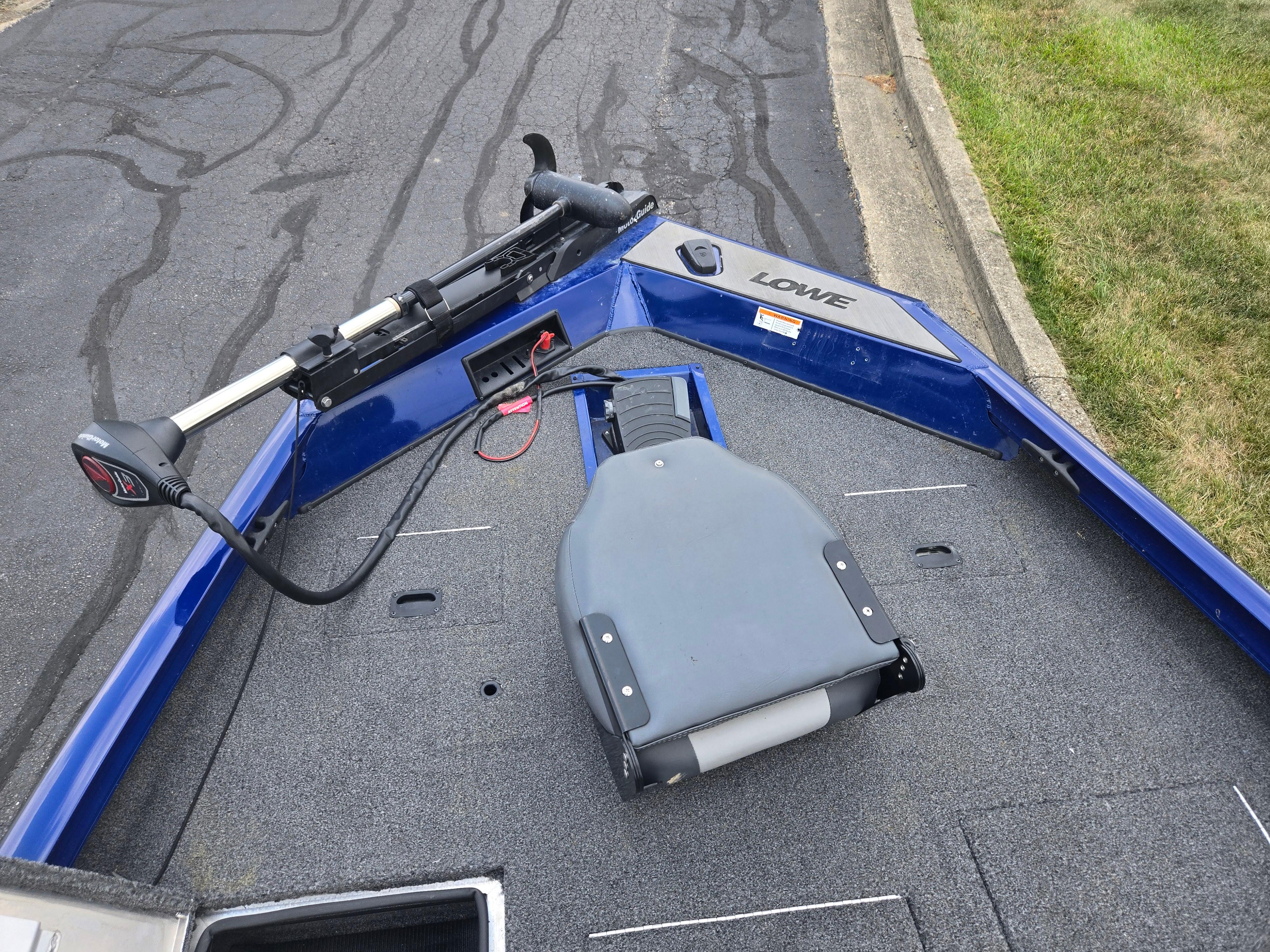 2021 Lowe Stinger 188 boat deck with trolling motor and seat, parked on asphalt.