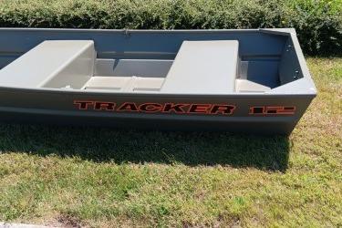 2026 Tracker Grizzly 12 Jon boat on grass, showcasing durable design and spacious seating.