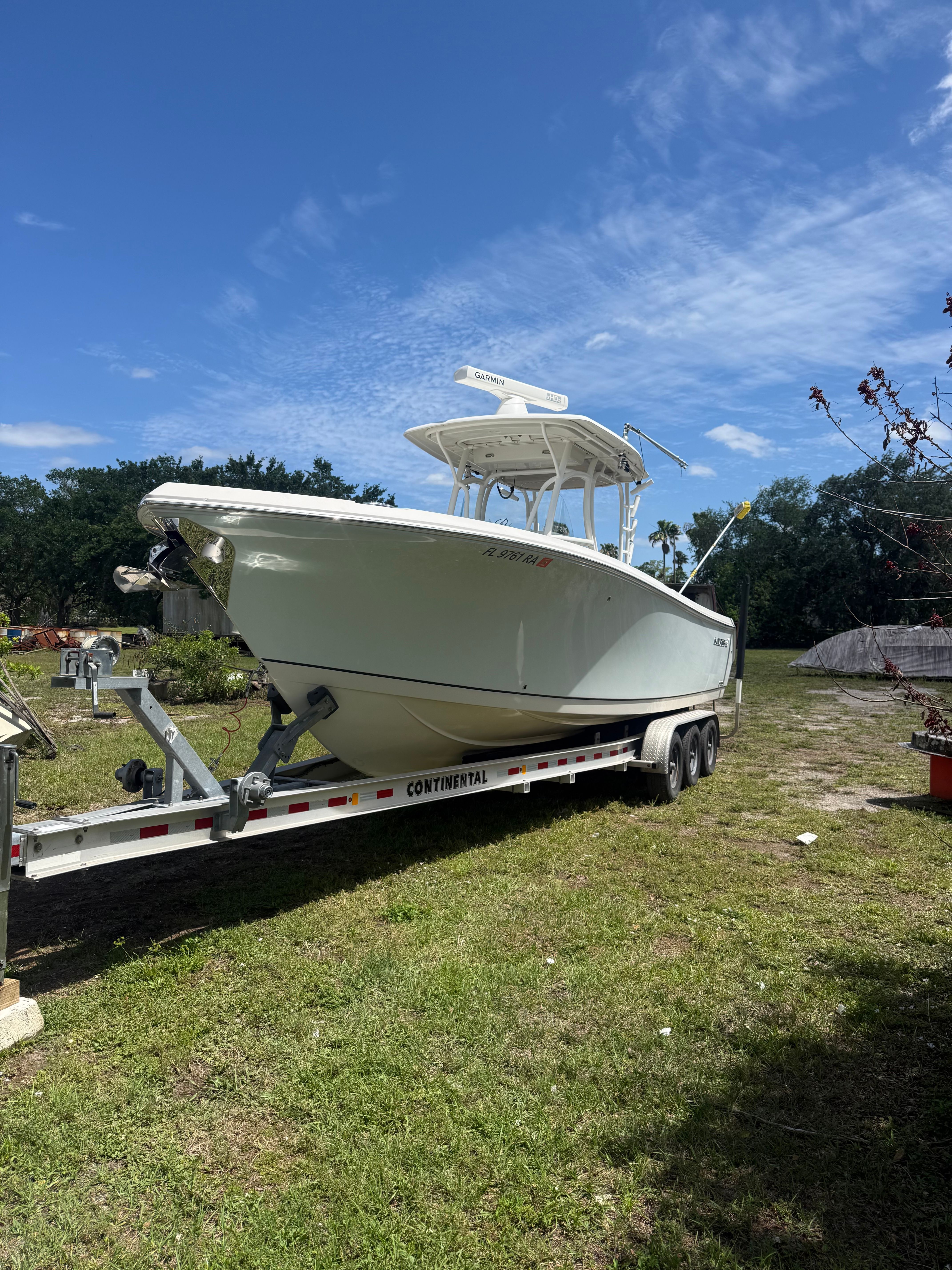 2015 Sailfish 290 CC boat on trailer outdoors.