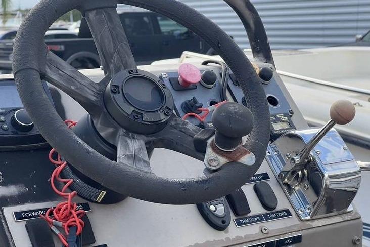 Steering console of 2016 Pro-Drive X Series 20' boat with controls and steering wheel.