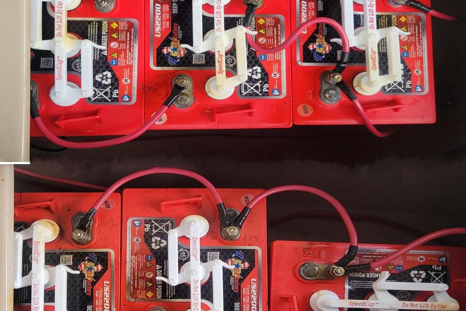 Red deep cycle batteries with connected cables in a 2008 Duffy Snug Harbor 18 boat.