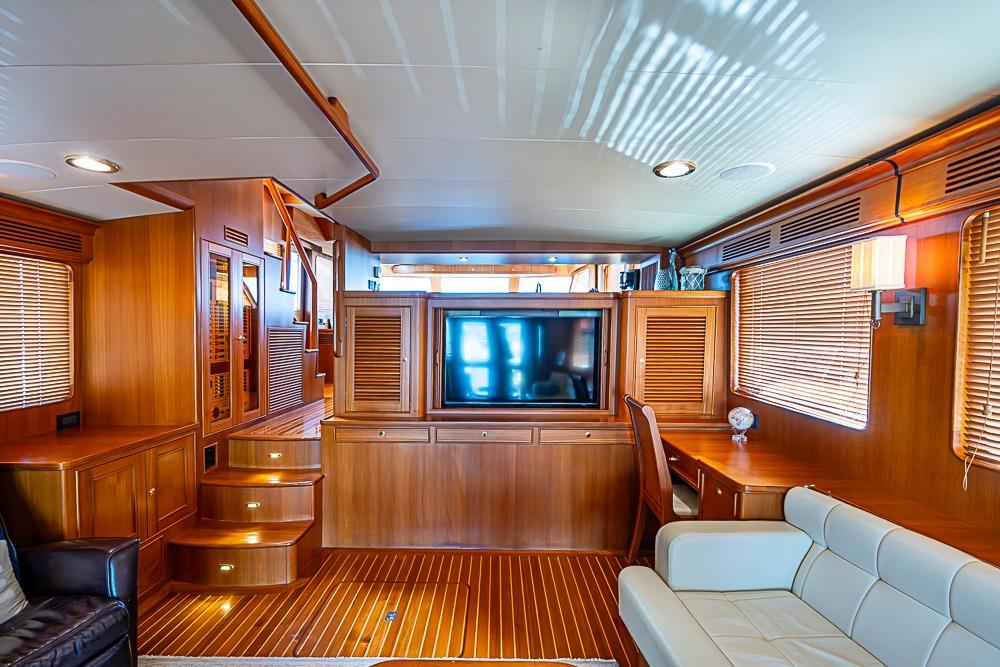 Luxurious interior of 2014 Marlow Explorer 66E yacht with wood paneling and modern furnishings.