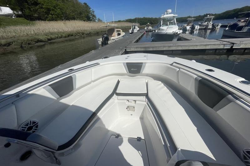 2023 Robalo R270 Center Console boat docked at a marina, featuring spacious seating.