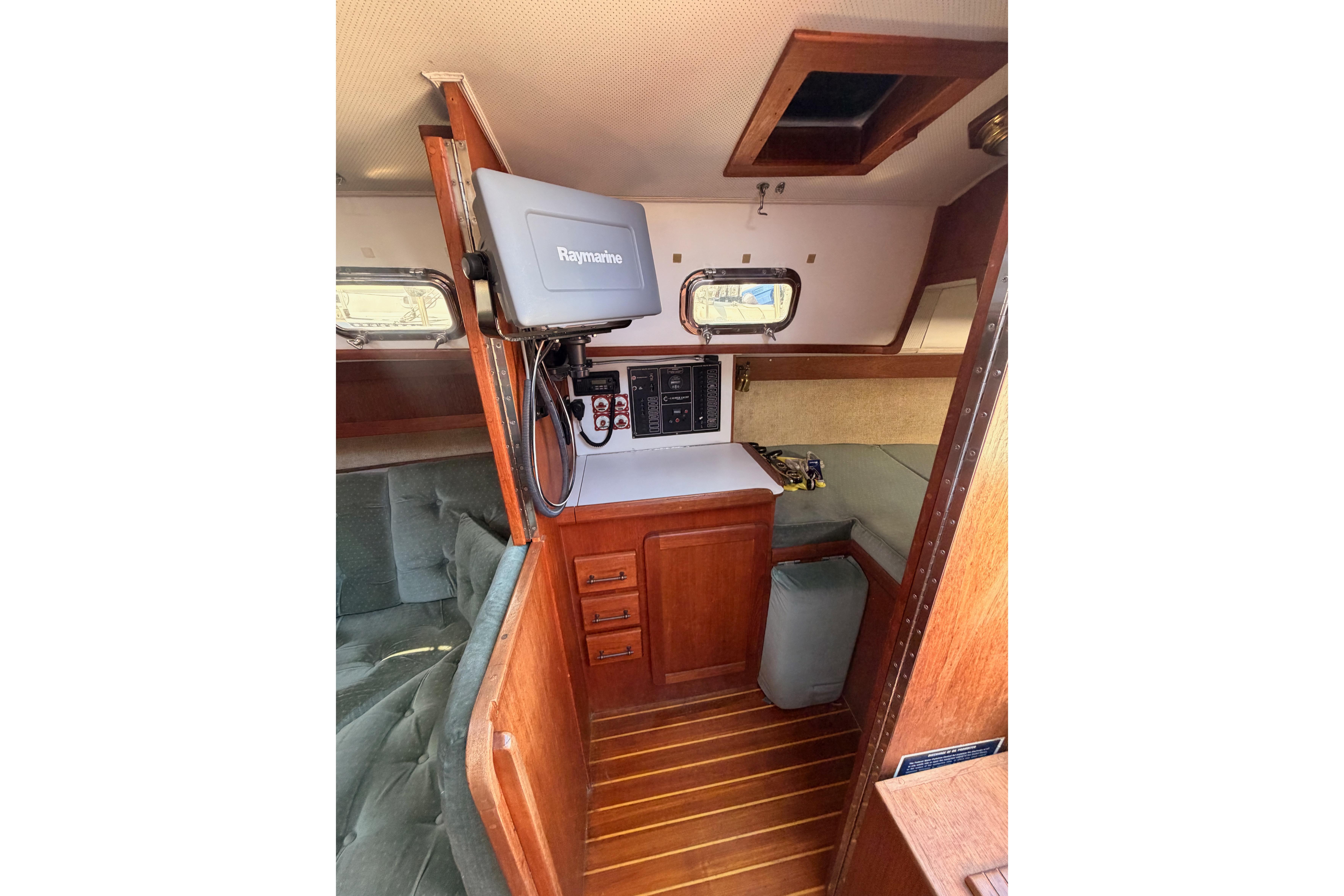 Interior of a 1991 Caliber 33 sailboat featuring navigation equipment and wooden cabinetry.