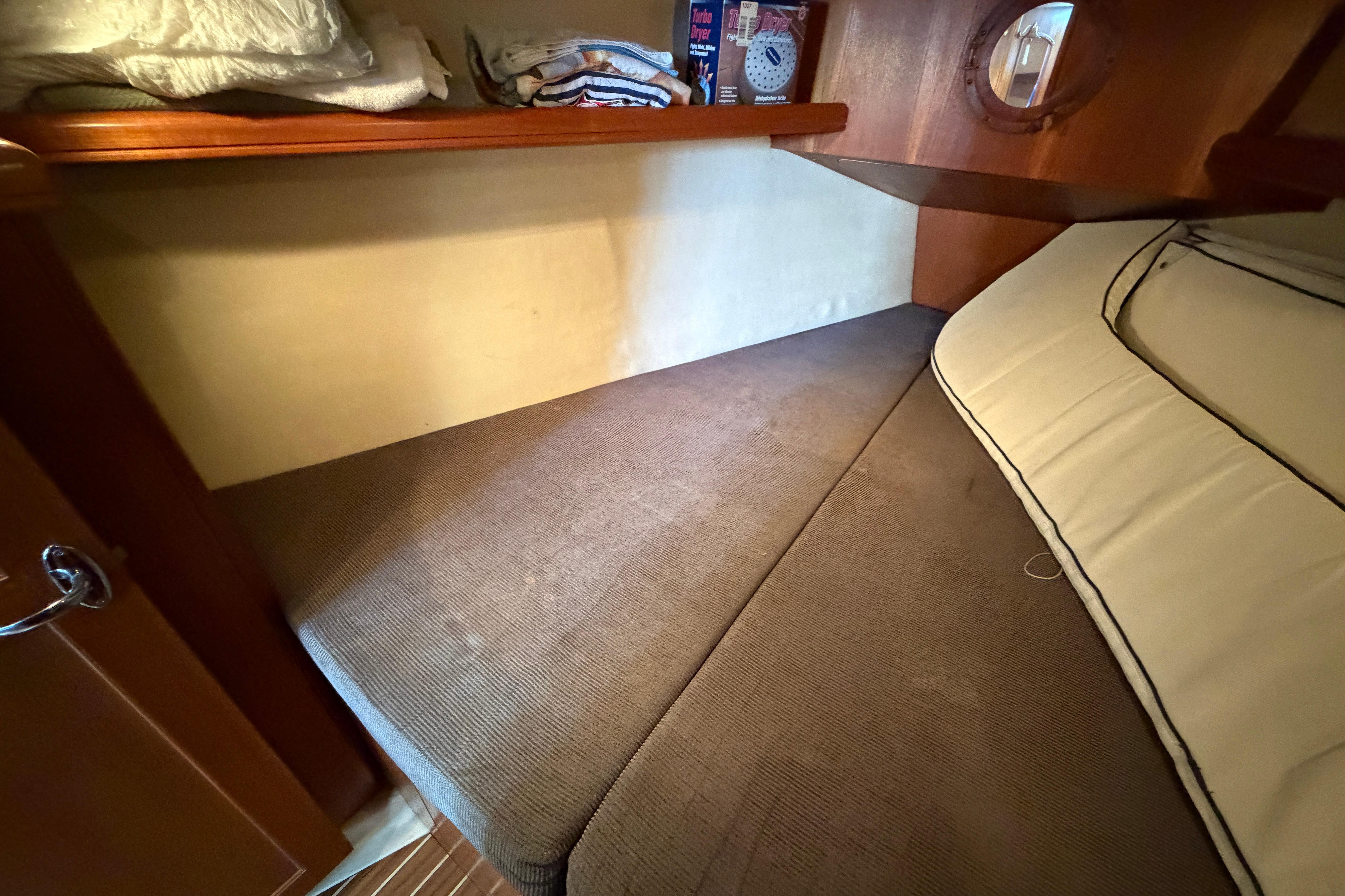 Cozy cabin interior of 2005 Hunter 38 sailboat with comfortable bedding and storage.