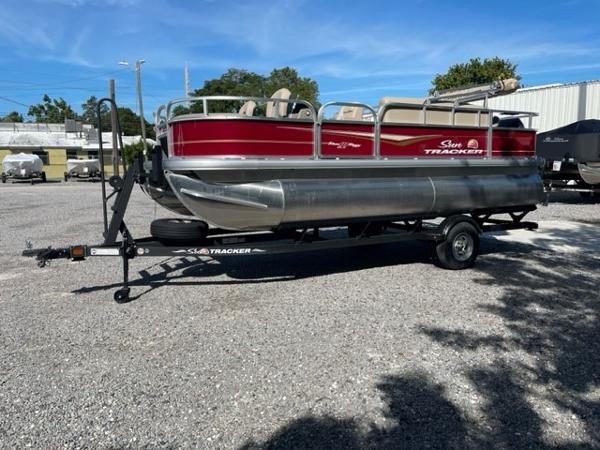 2024 Sun Tracker Bass Buggy 18 DLX pontoon boat on trailer in outdoor lot.