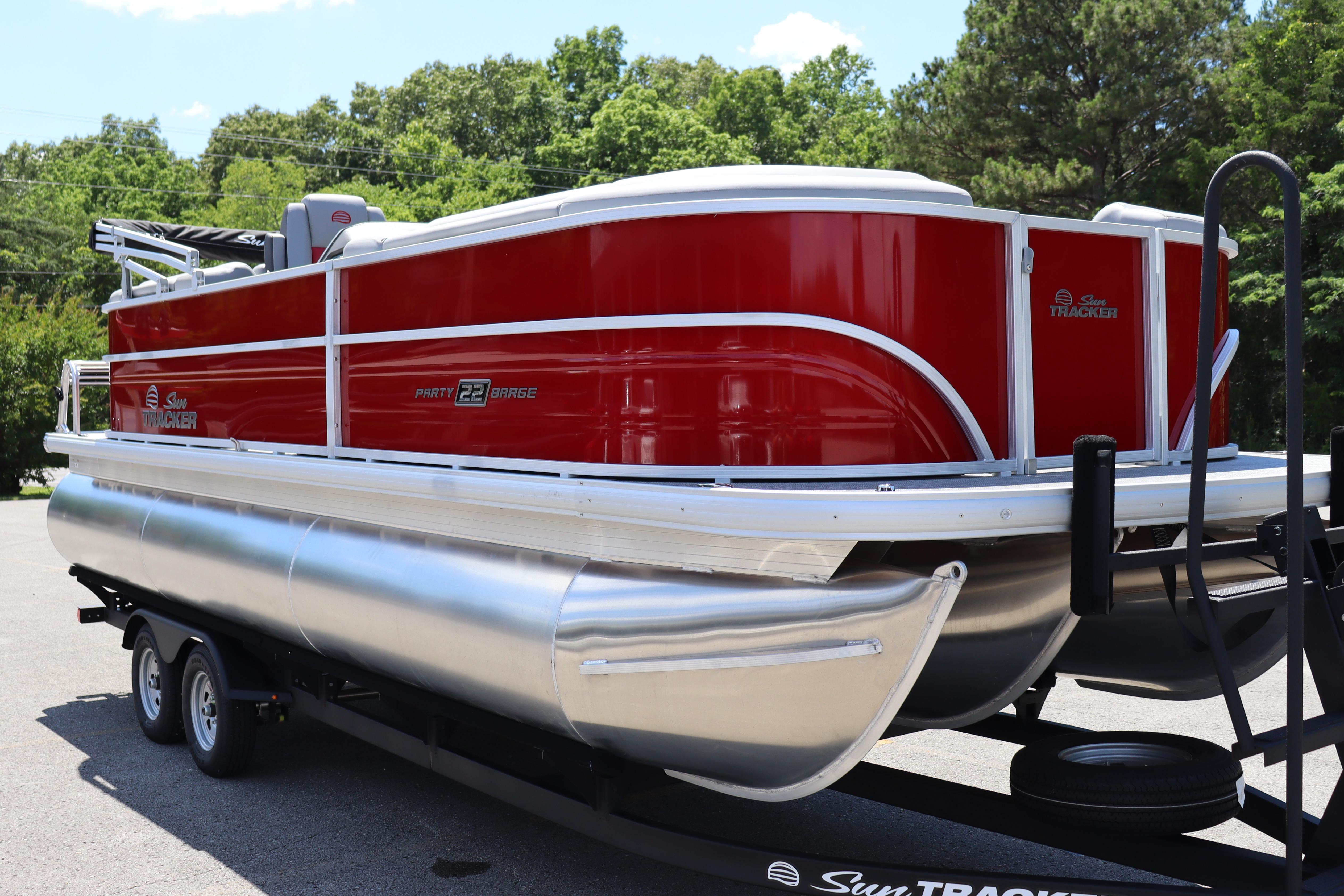 2026 Sun Tracker Party Barge 22 XP3 pontoon boat on trailer, vibrant red exterior.