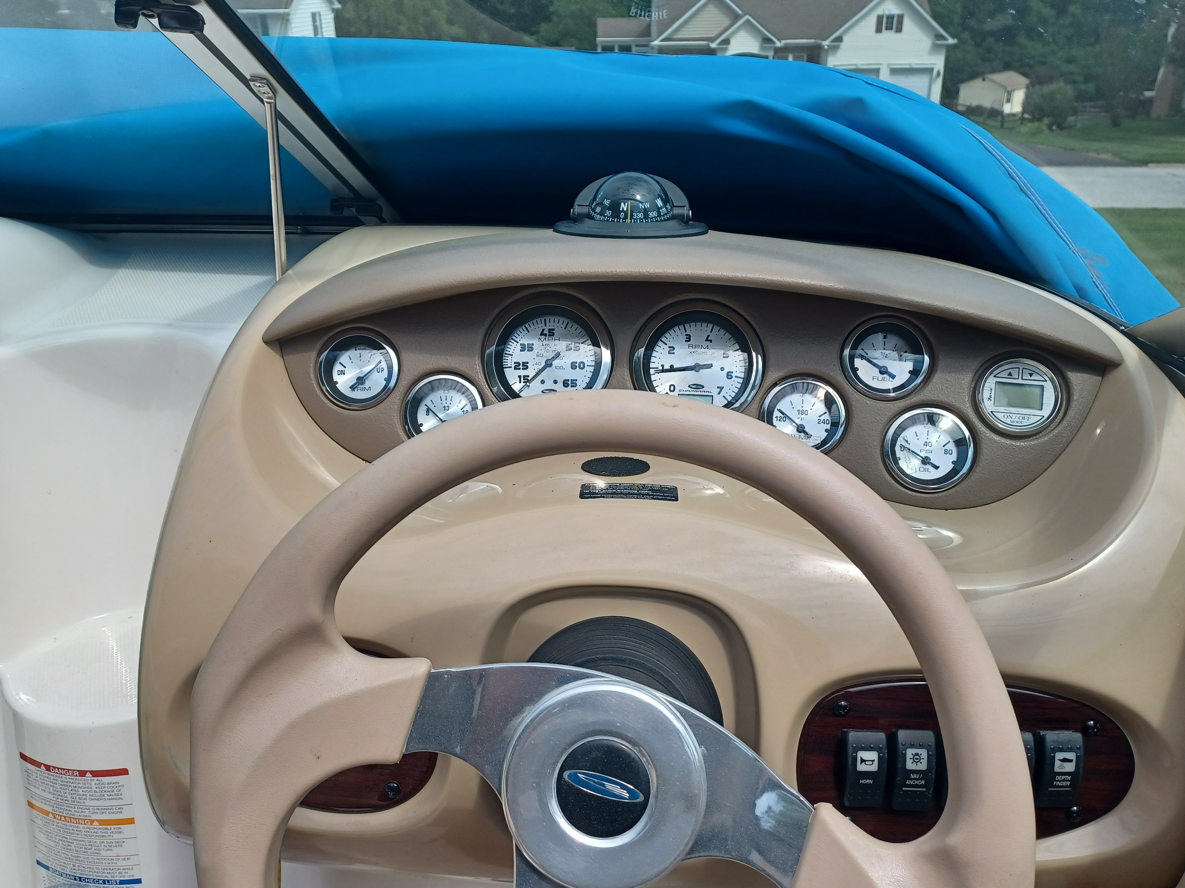 Dashboard of a 2004 Chaparral 215 SSi boat with steering wheel and gauges.