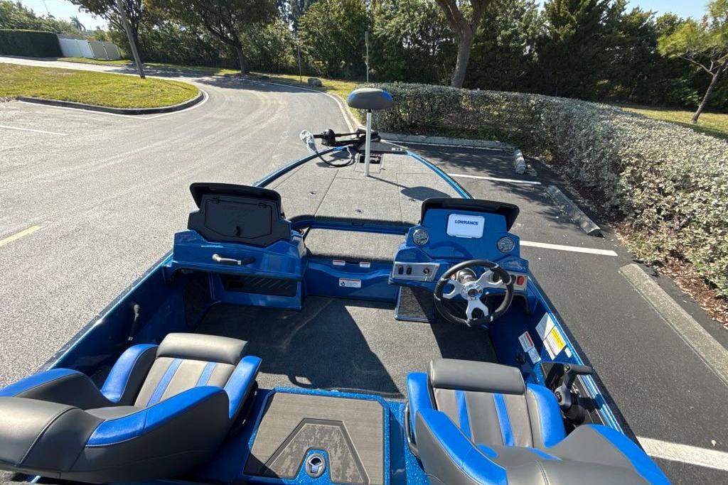 2026 Nitro Z19 XL boat interior with blue seats and steering wheel in a parking lot.