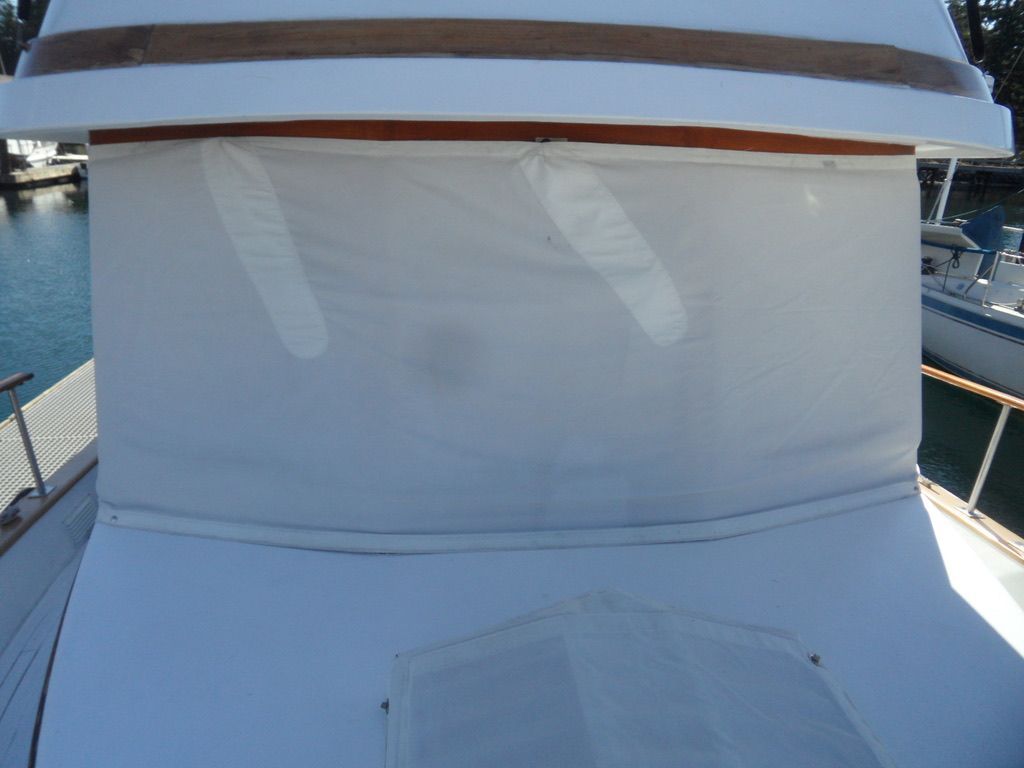 1976 CHB Trawler with covered deck area, docked at marina.