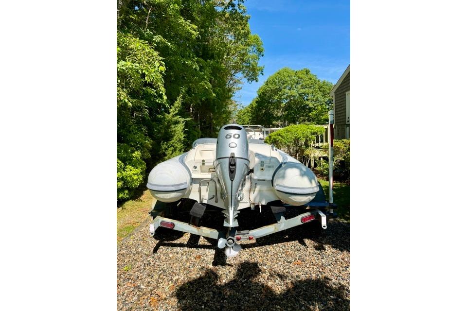 2016 Walker Bay Generation 450 DLX boat on trailer, surrounded by lush greenery.