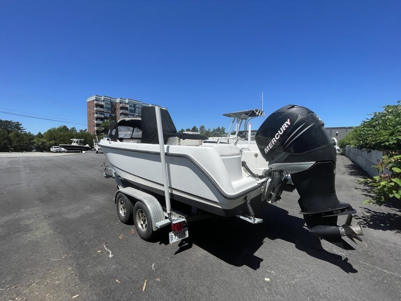2006 Boston Whaler 210 Outrage boat on trailer with Mercury engine, parked outdoors.