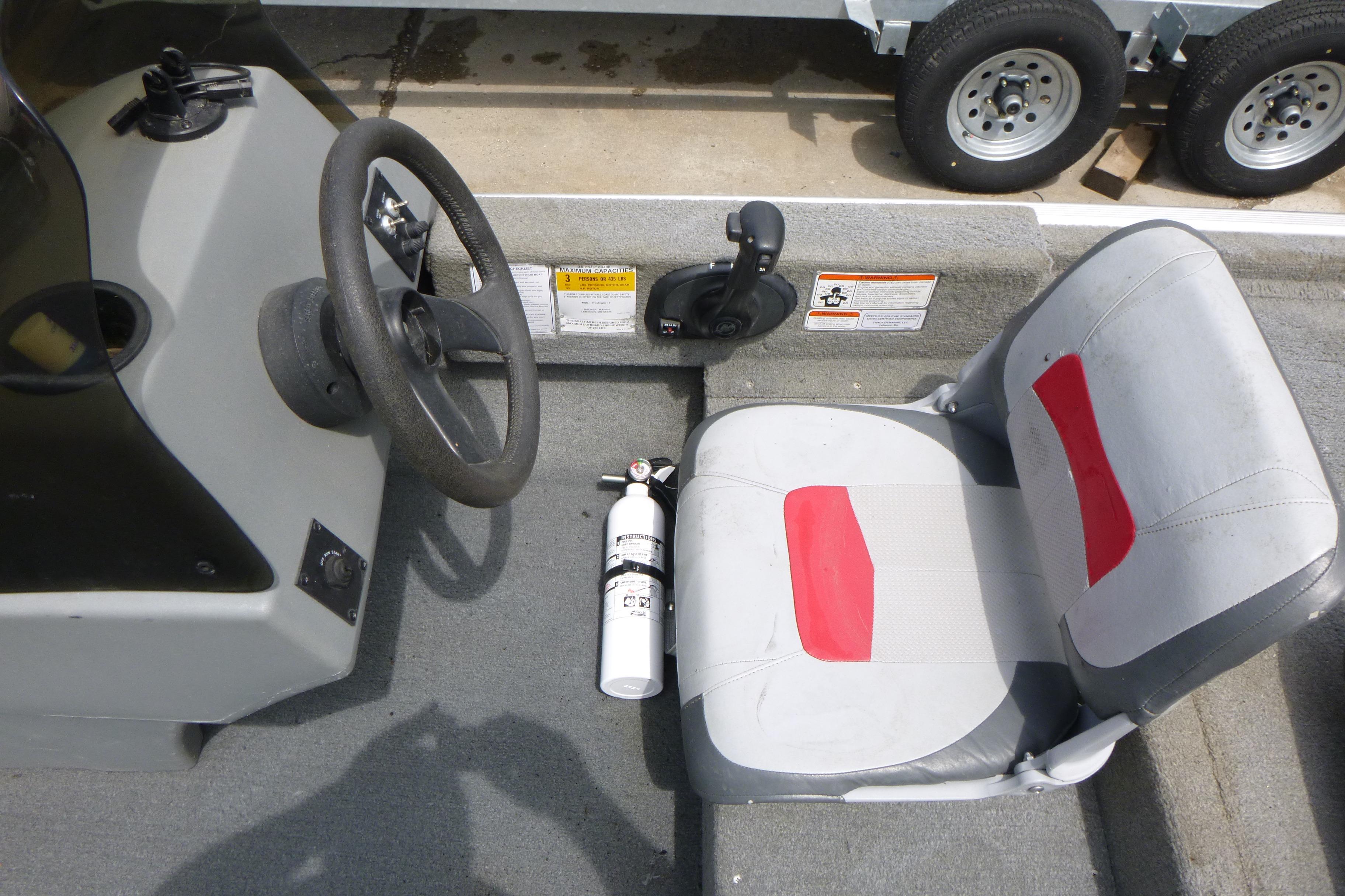 Interior of 2011 Tracker Pro Angler 16 boat with steering wheel and seat.