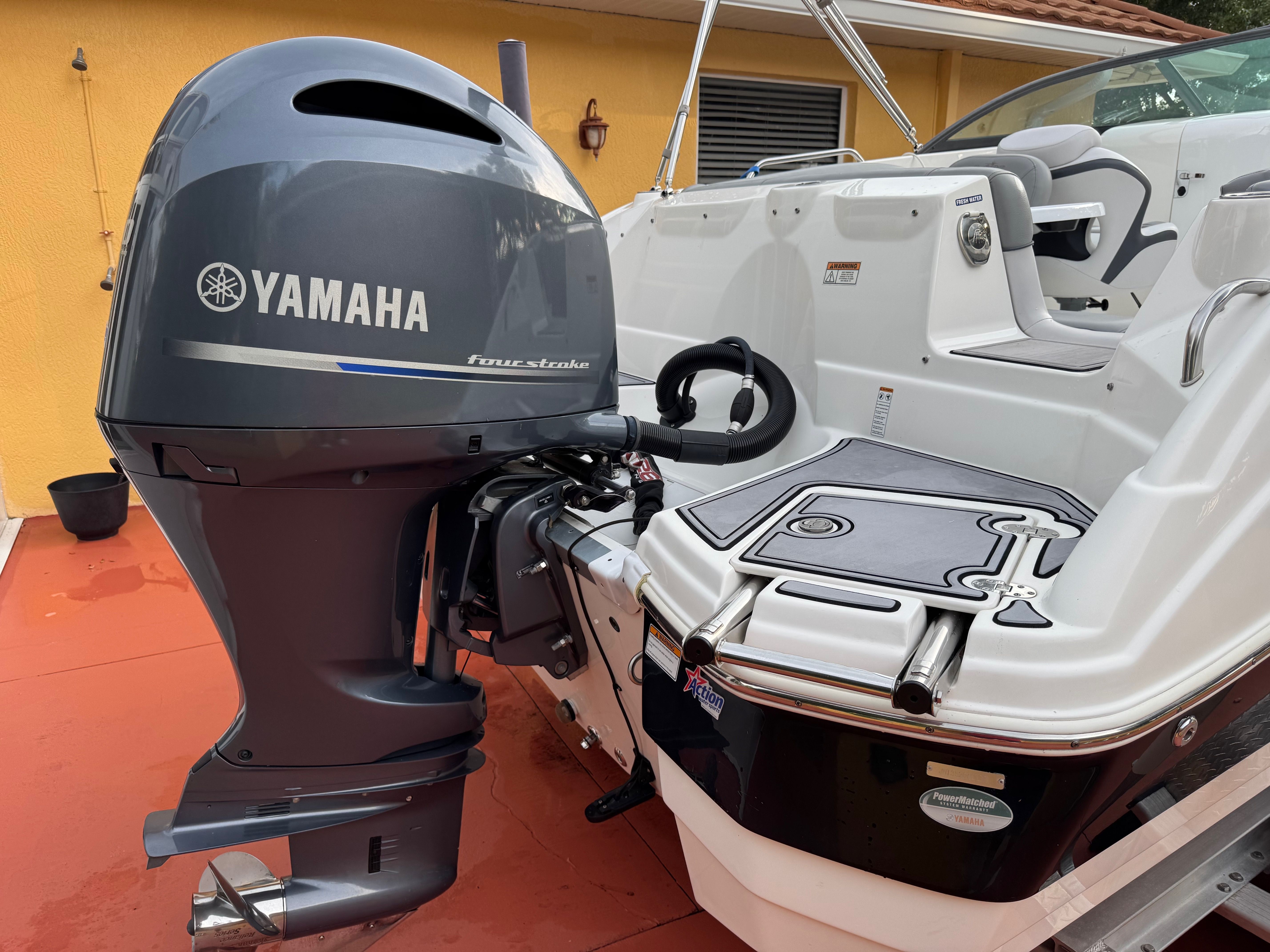 A Yamaha outboard motor is mounted on a NauticStar 243 DC boat, positioned on a patio.