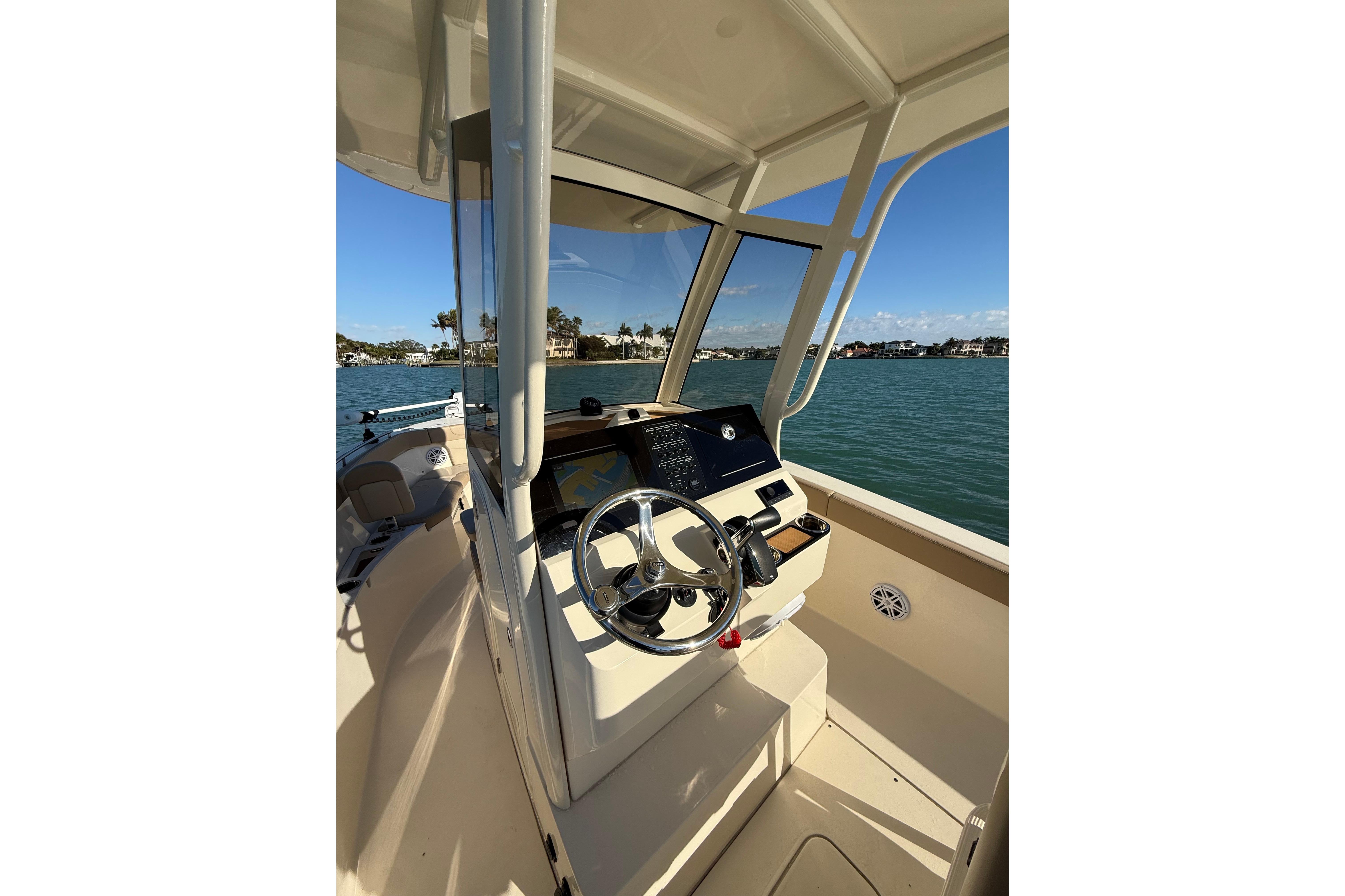2024 Scout 240 XSF boat interior with steering wheel, dashboard, and ocean view.