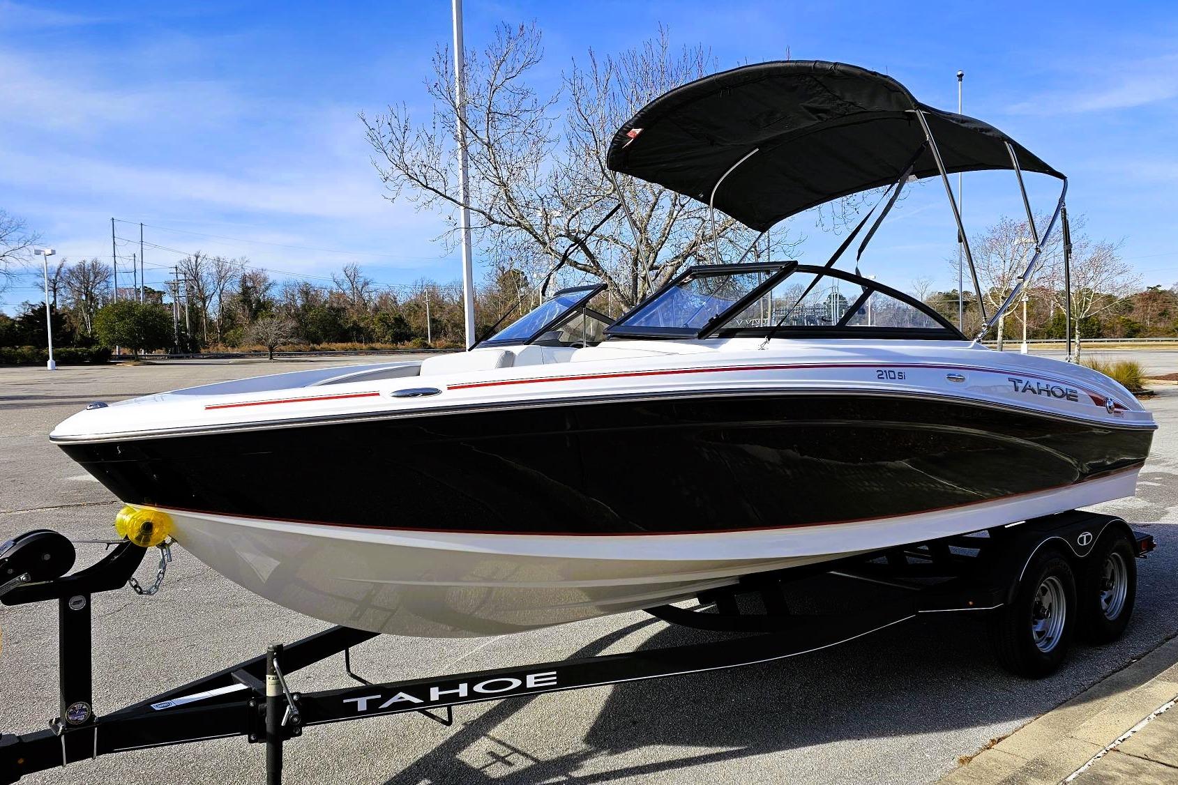 2023 Tahoe 210 Si boat on trailer, black and white design, parked outdoors.