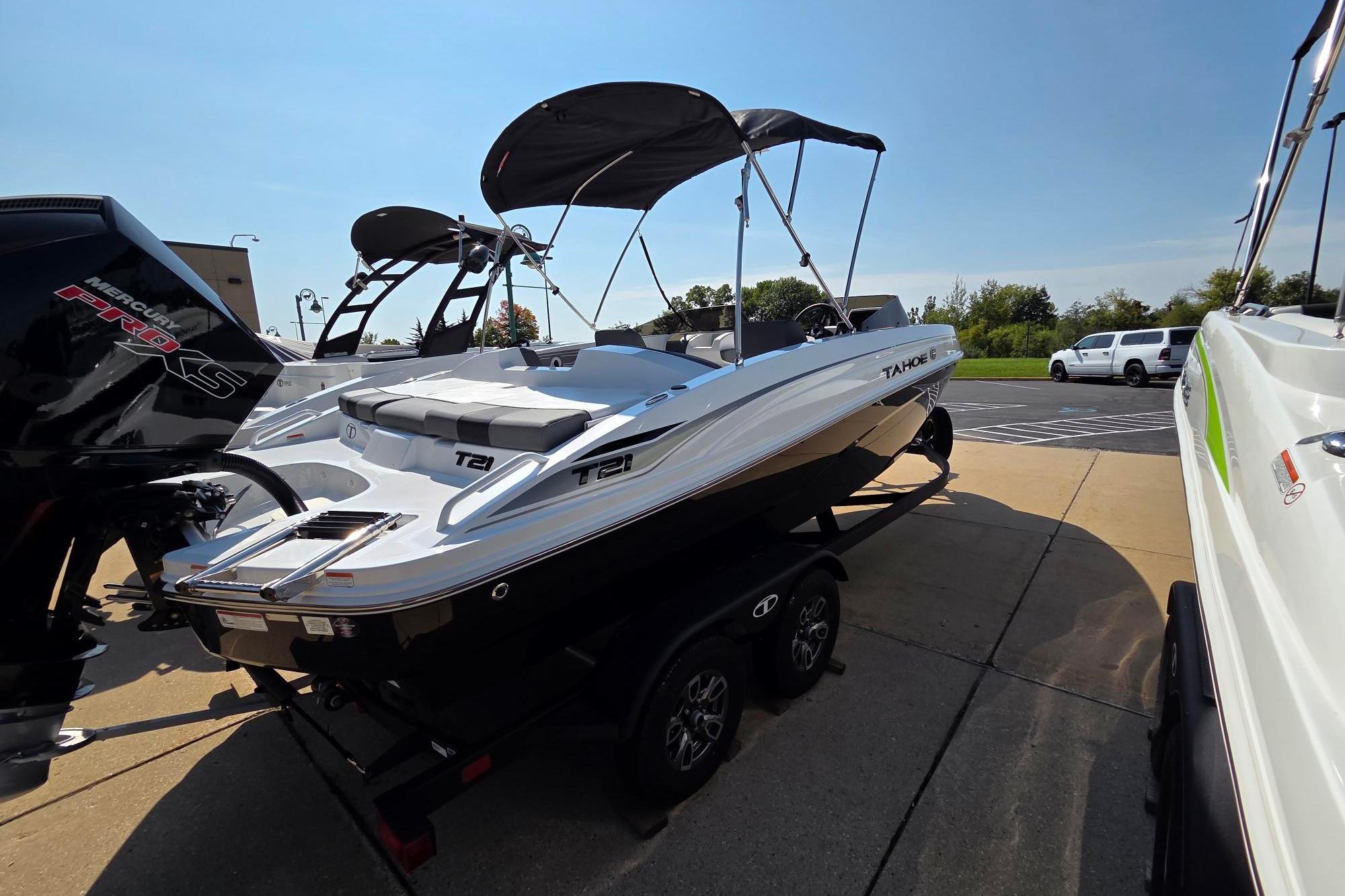2025 Tahoe T21 boat with Mercury Pro XS engine, parked outdoors.