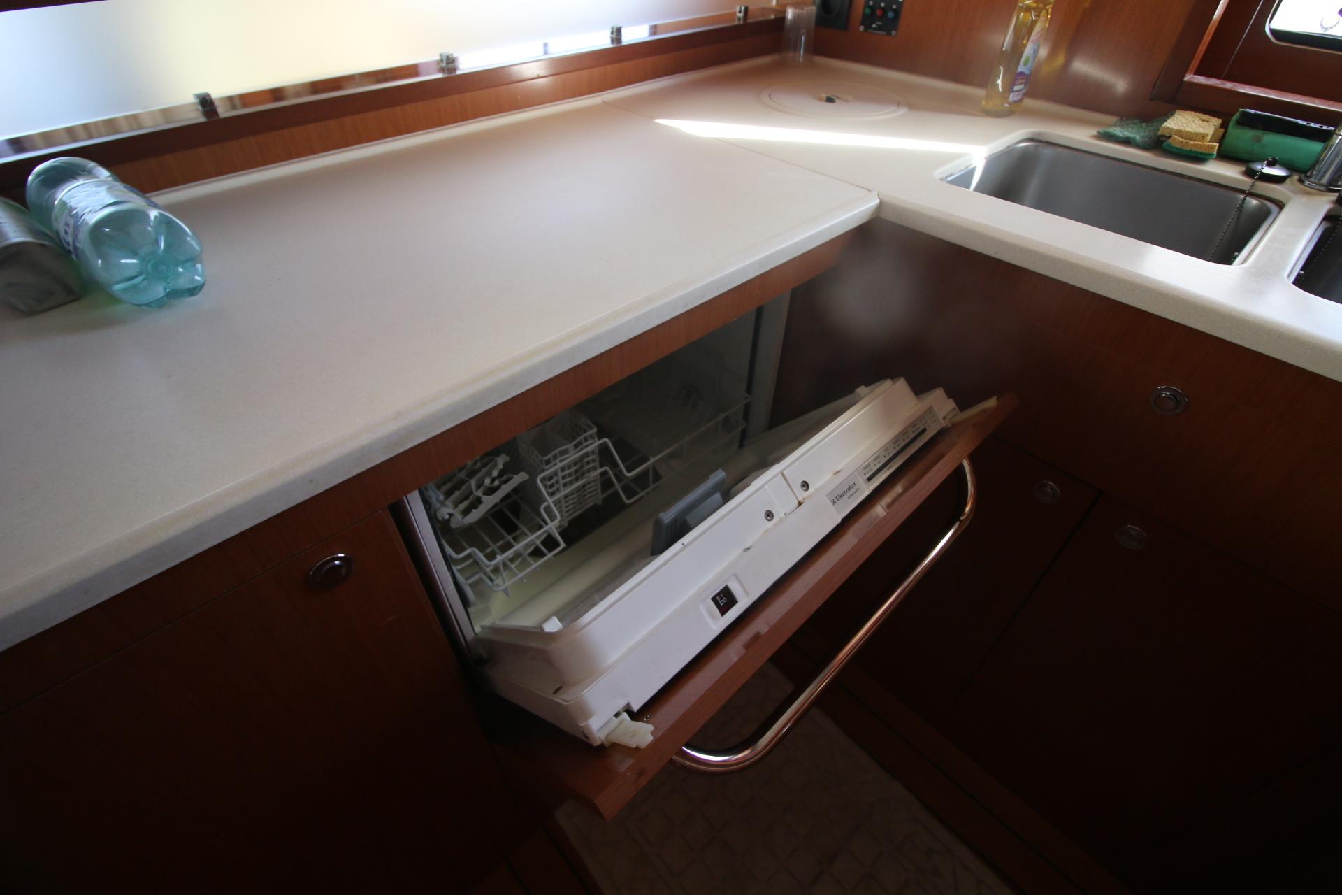 Kitchen area of 2008 Beneteau Swift Trawler 52 with open dishwasher.