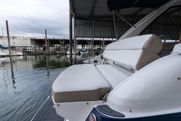 2016 Regal 28 Express boat with cushioned seating at a marina dock.